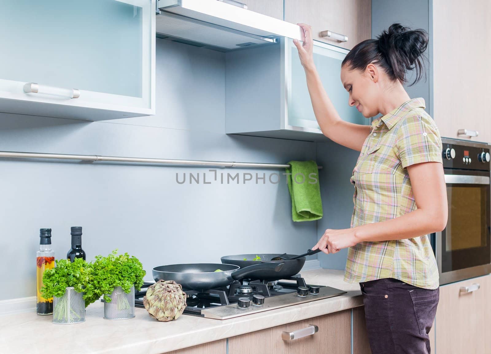 Portrait of a girl cooking at the kitchen. Vertical view