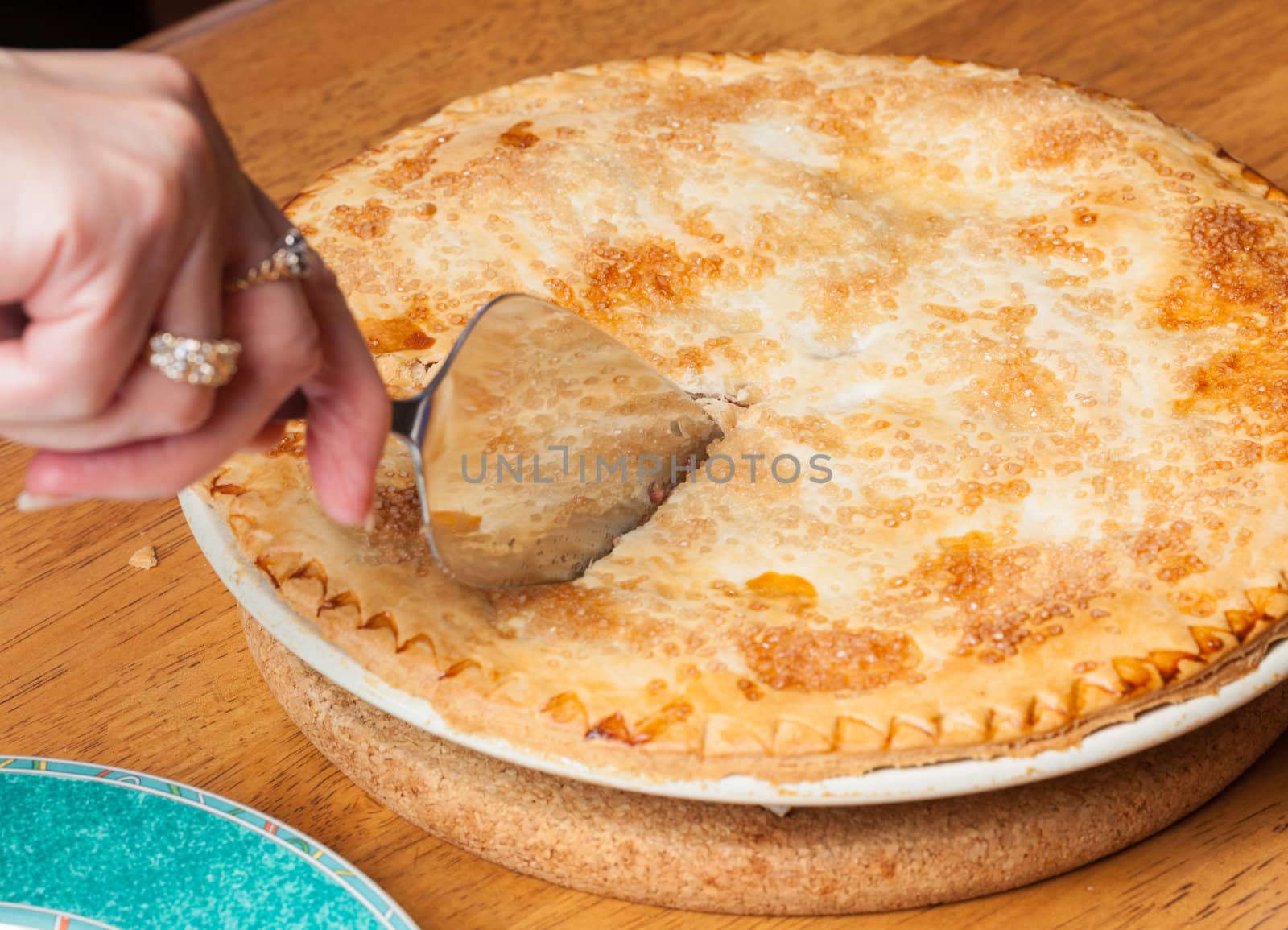 Home made baked fruit pie from oven and on table being cut with knife