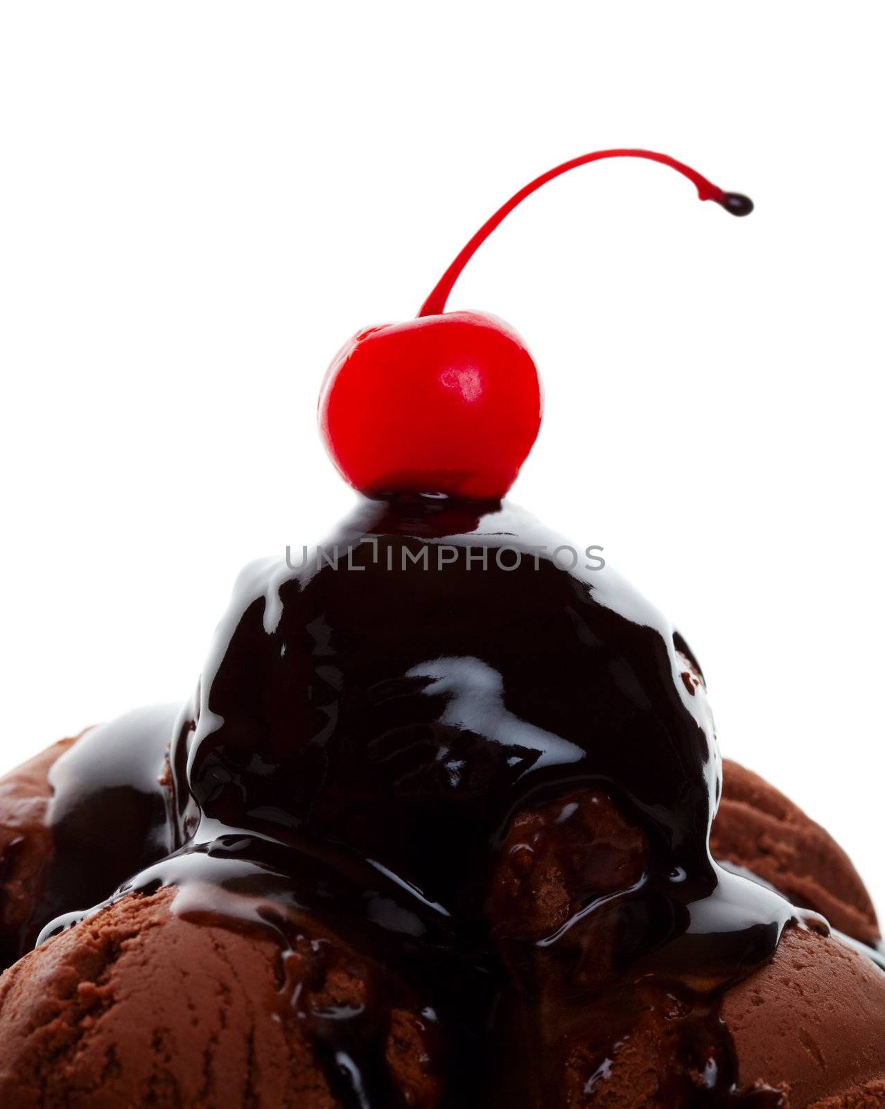 Chocolate ice cream covered with gooey chocolate syrup and topped with a yummy red cherry.  Shot on white background.