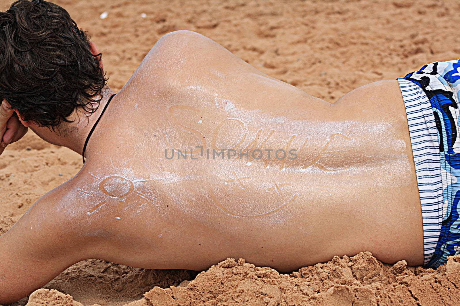 man painted on the beach with sun cream by photochecker