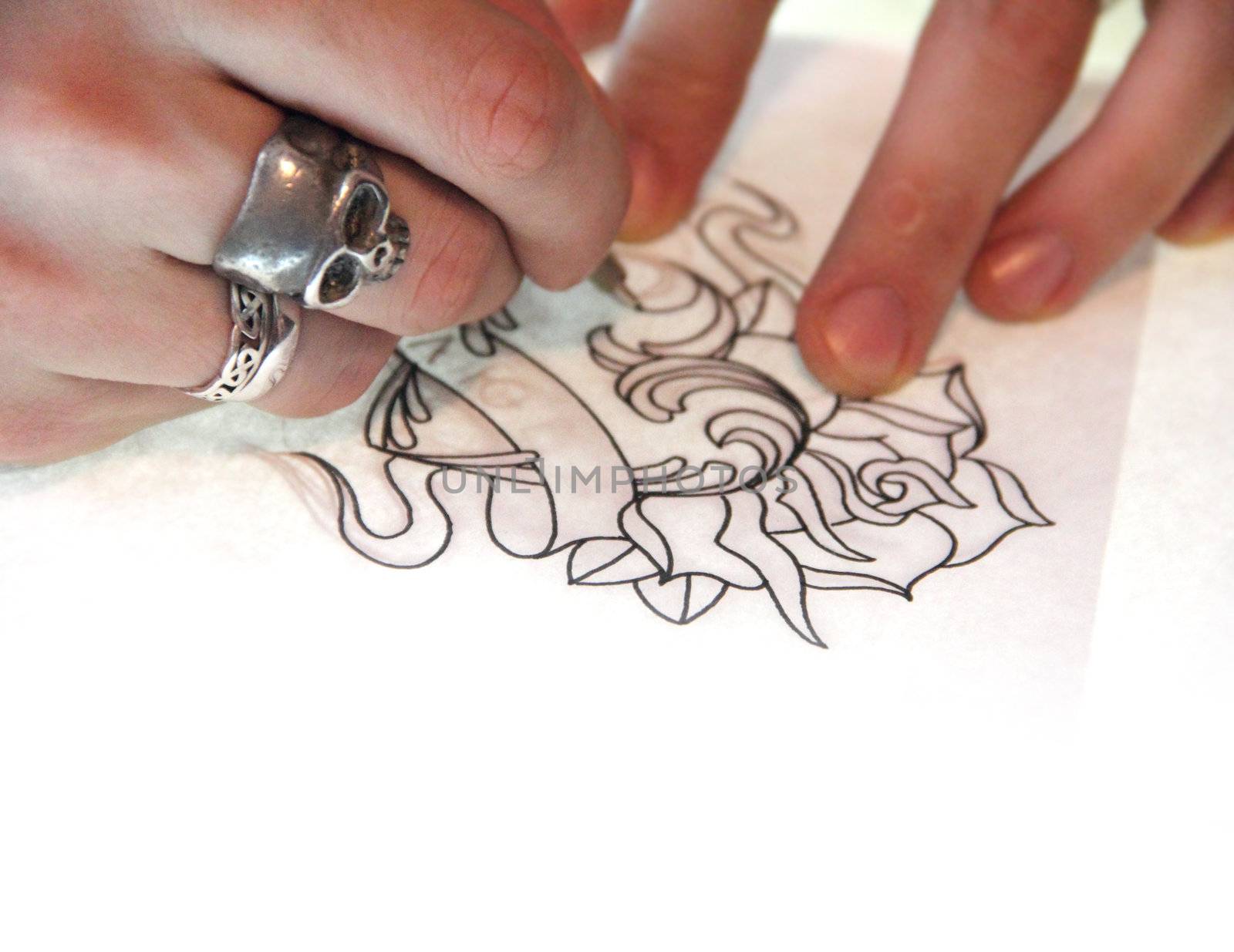 Artist drawing sketch of tattoo on white paper