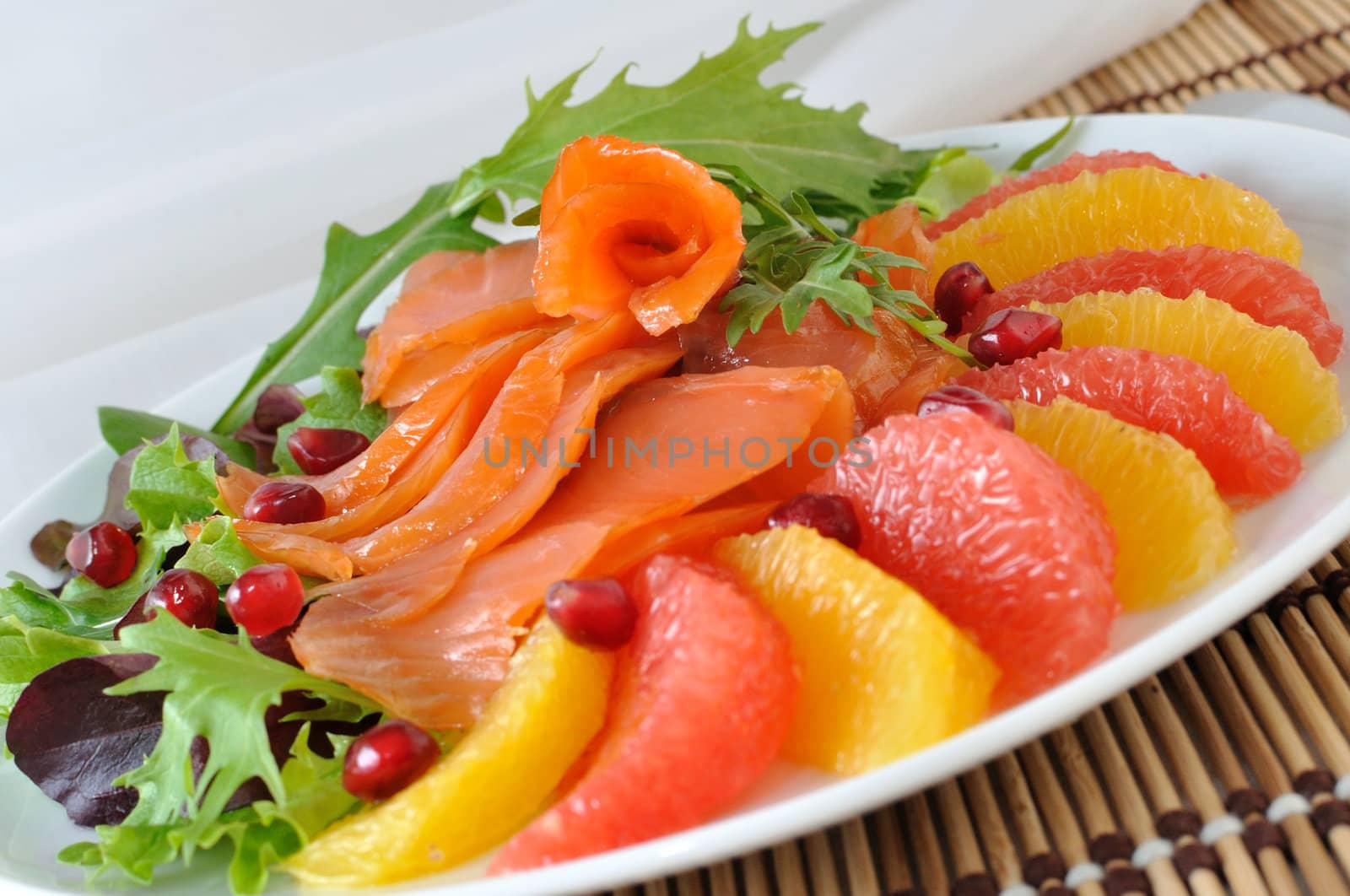 Appetizer of salmon with orange and grapefruit and a mixture of lettuce