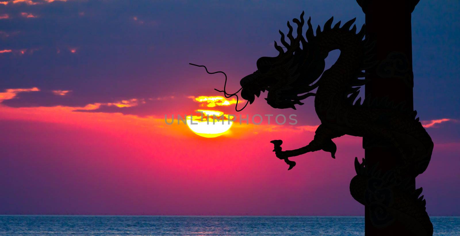 Dragon silhouette and sunset in the sea