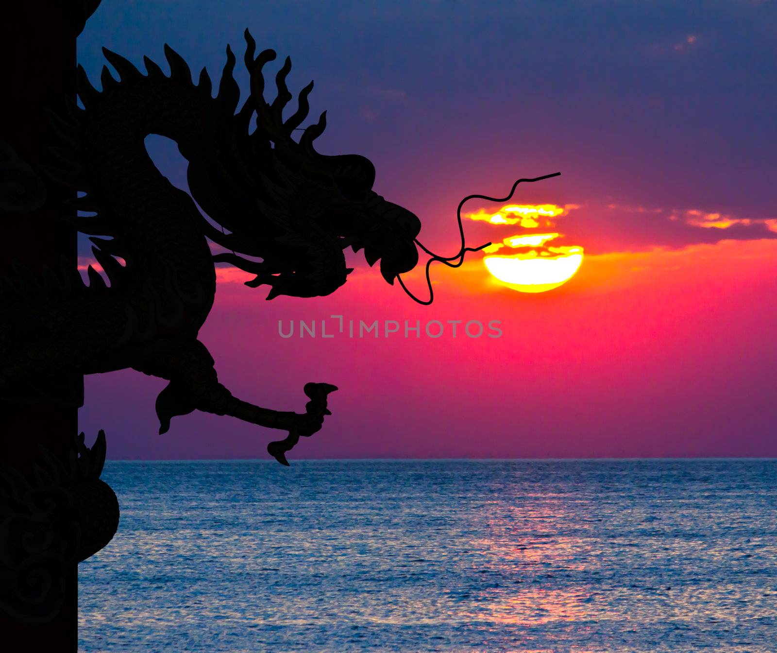 Dragon silhouette and sunset in the sea