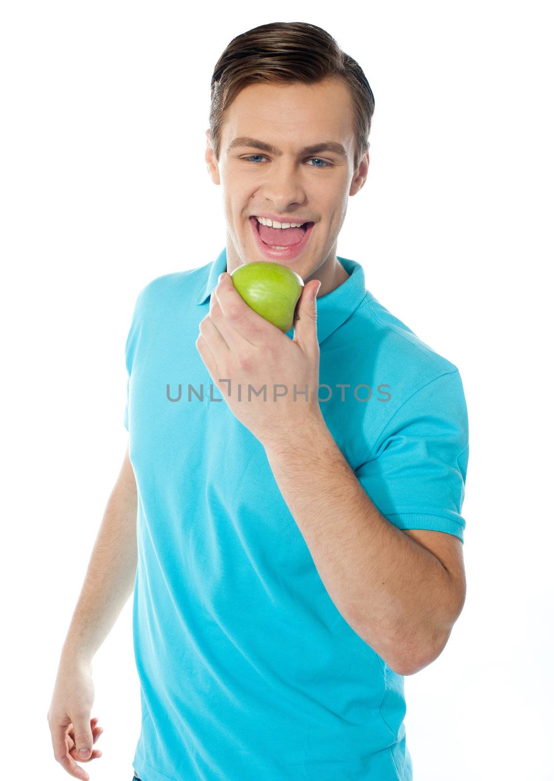 Young caucasian biting an apple on white background