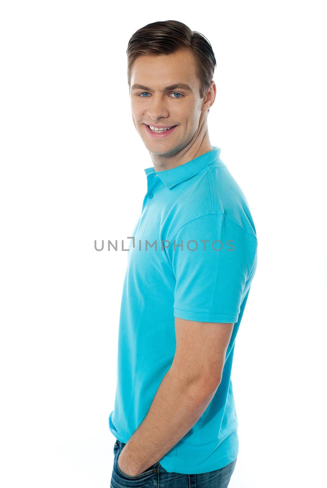 Side view of smiling young man with hands in the pocket on white background