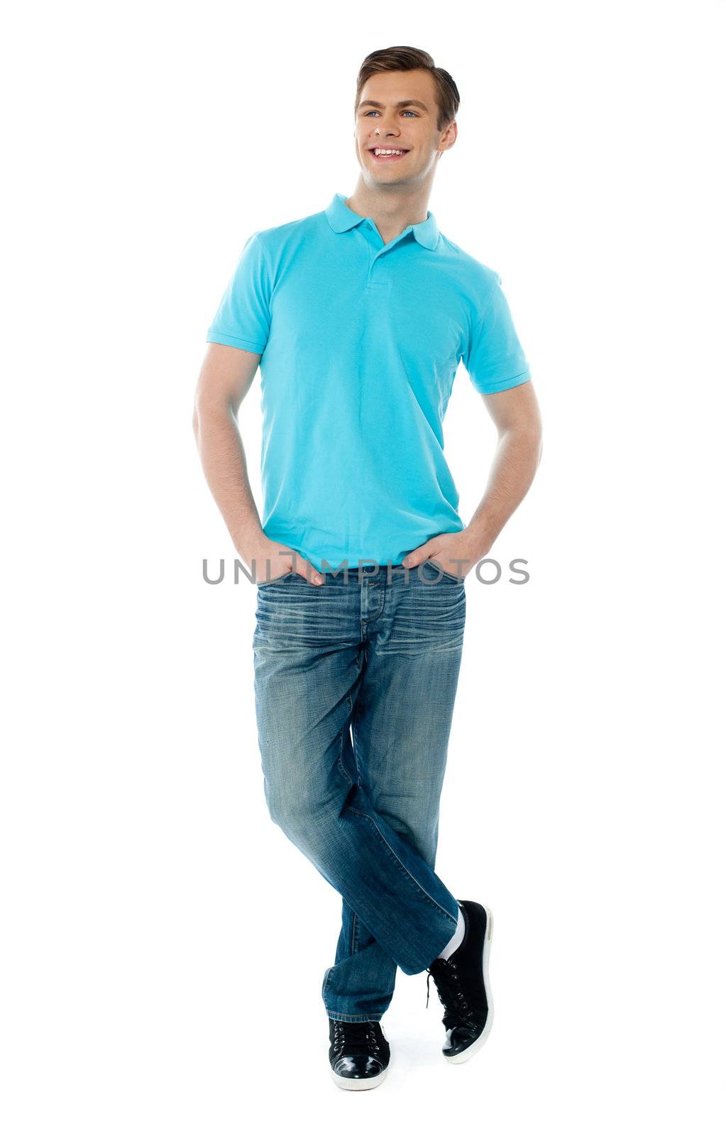 Full-body pose of smiling man posing in casuals with crossed legs