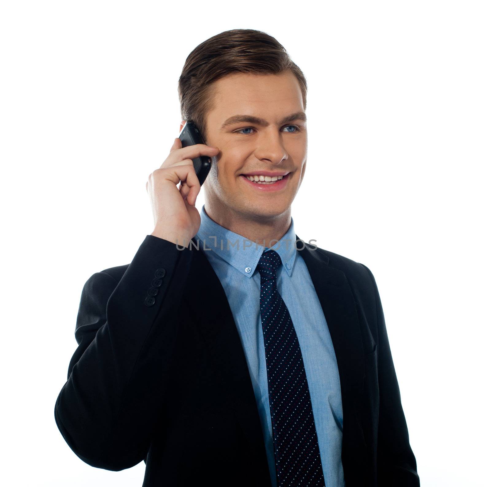 Corporate young man communicating via cell phone at work