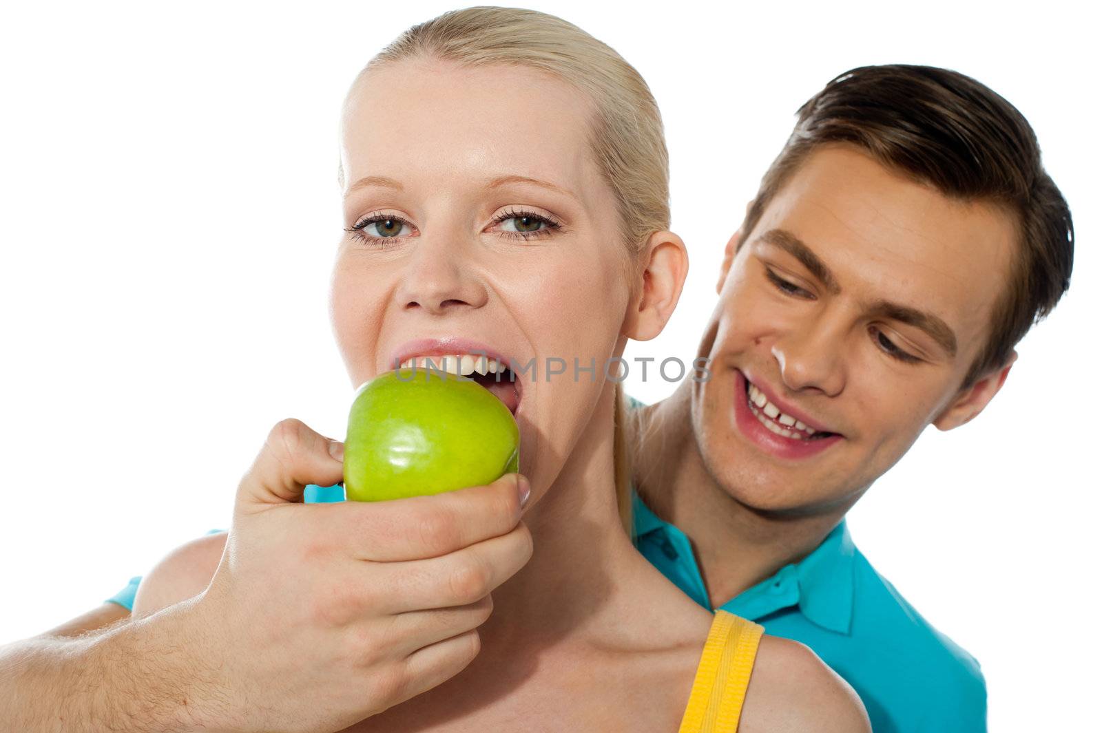 Boyfriend making her partner eat an apple. Love couple