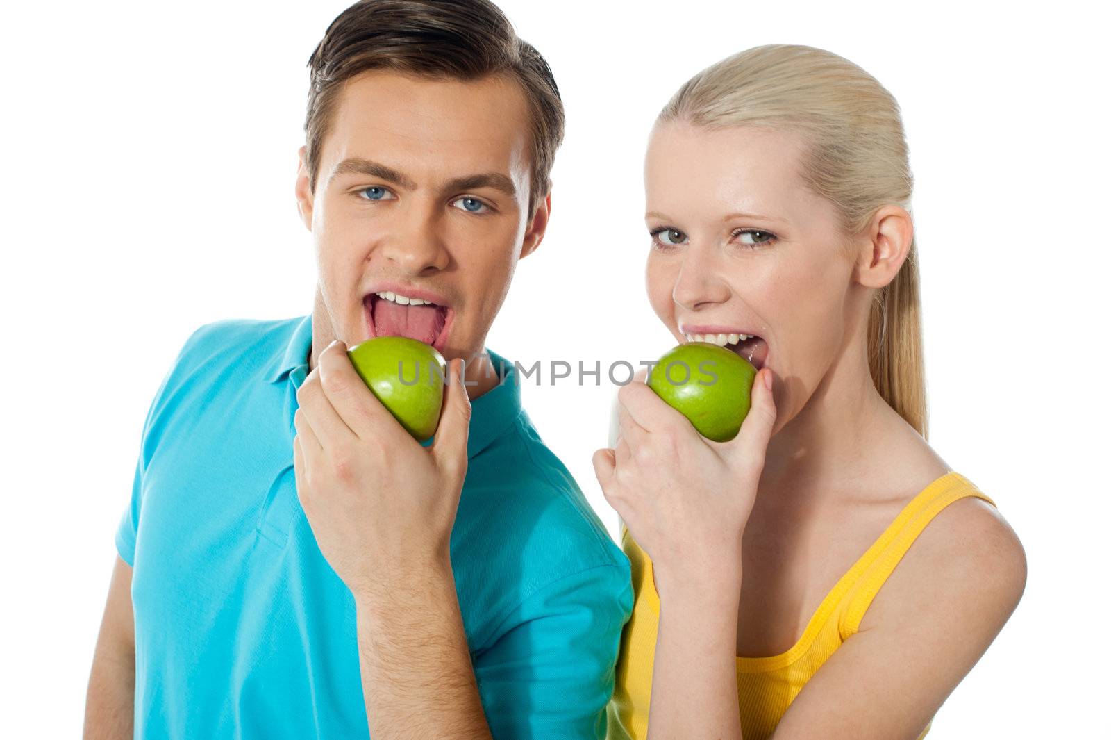 Healthy couple eating fresh green apple by stockyimages