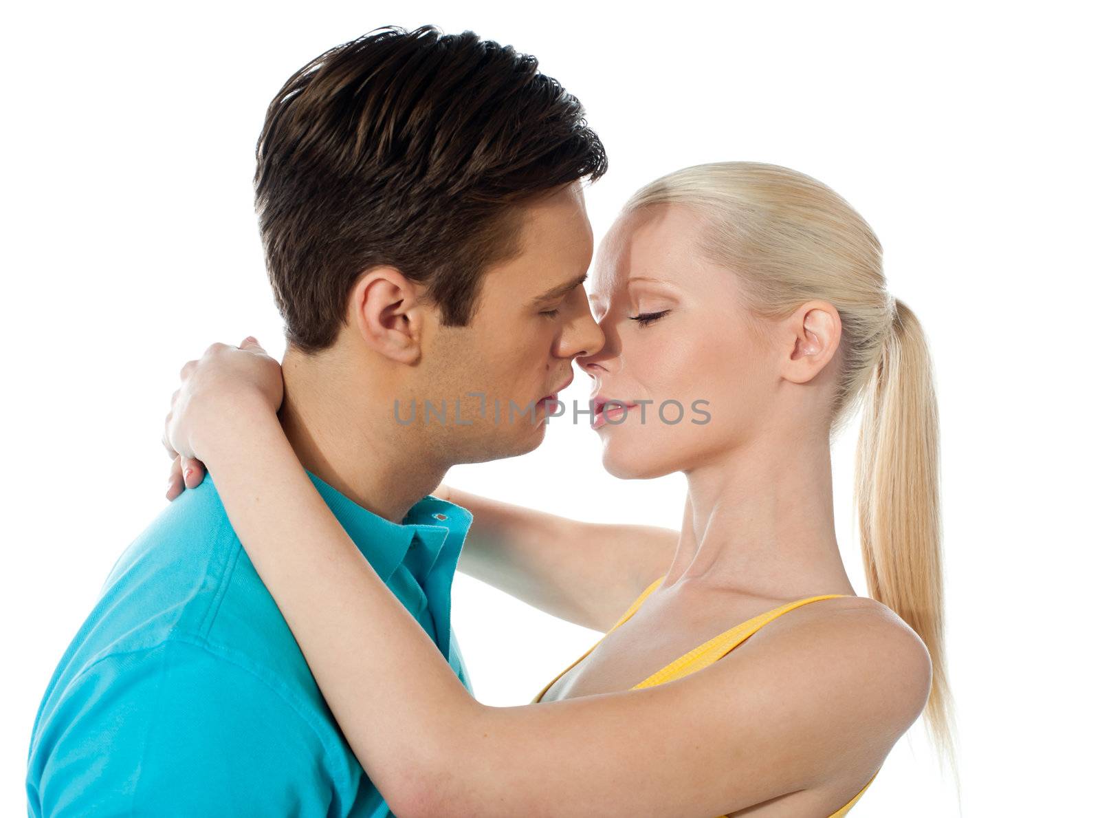 Young couple hugging and kissing on white background