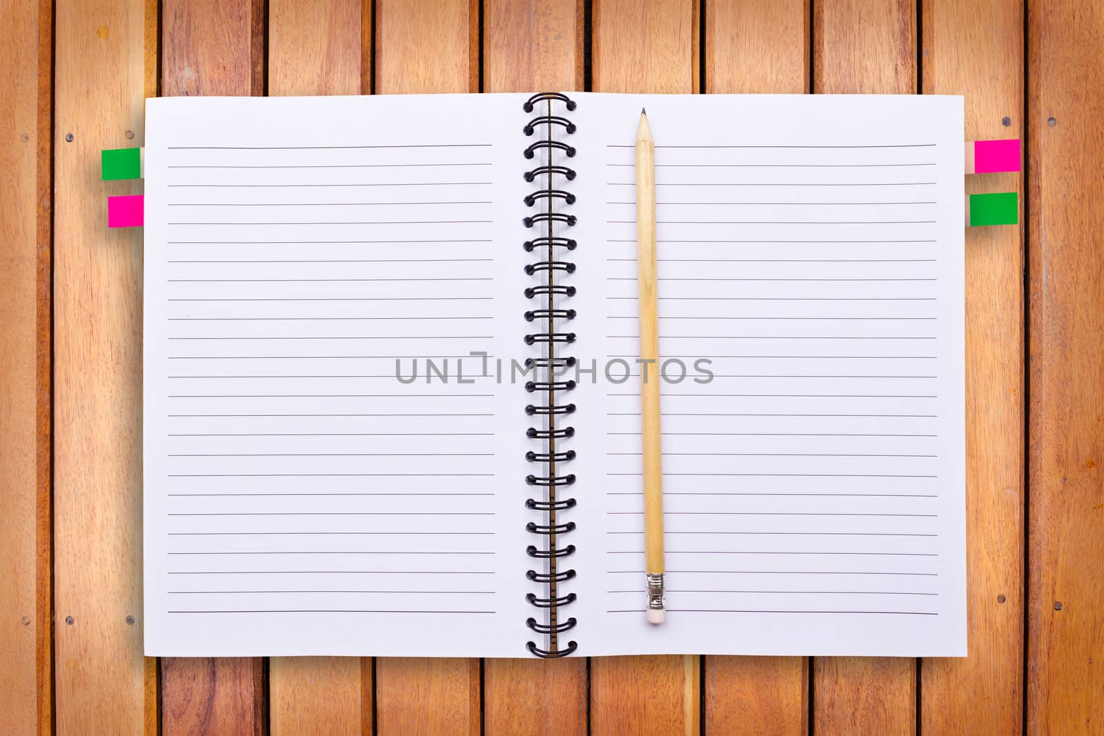 notebook and pencil on wood background
