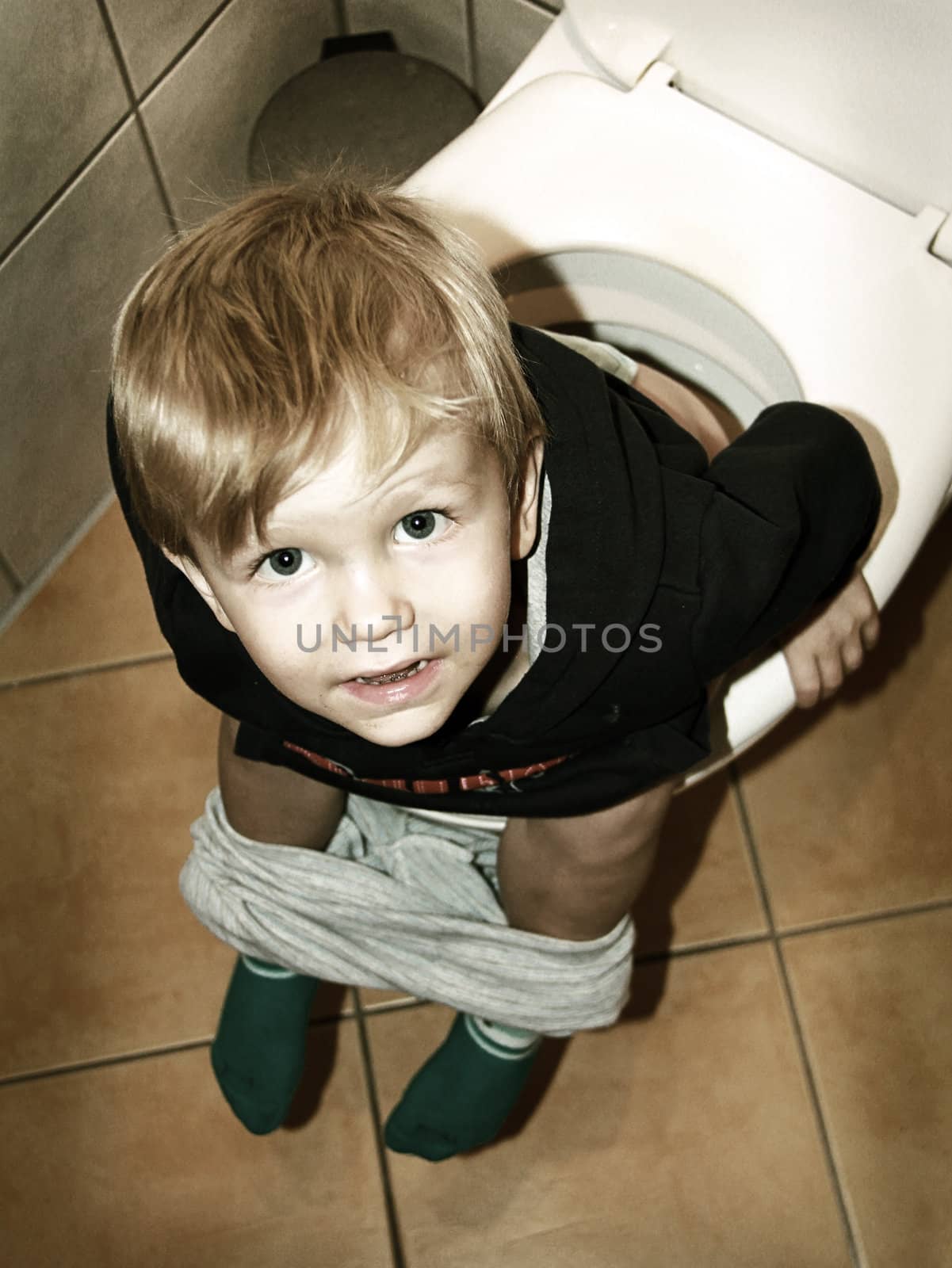 little boy is sitting on the toilet