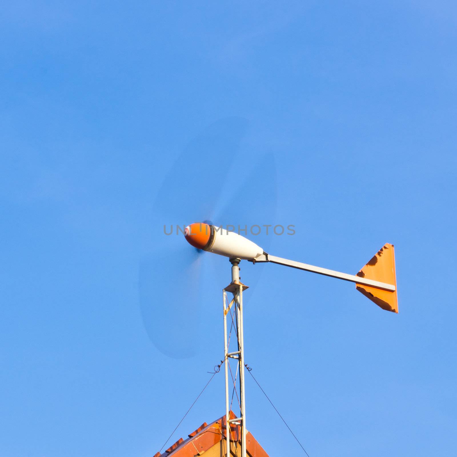 wind turbine on the roof against blue sky