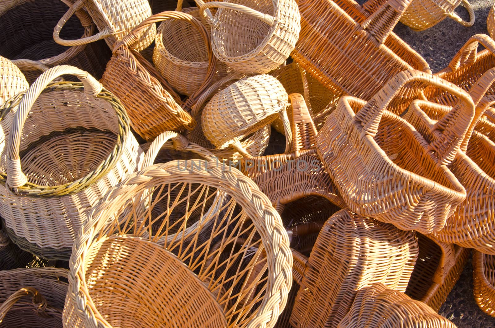 Handmade basket bags stacked in pile sell in outside street fair market.