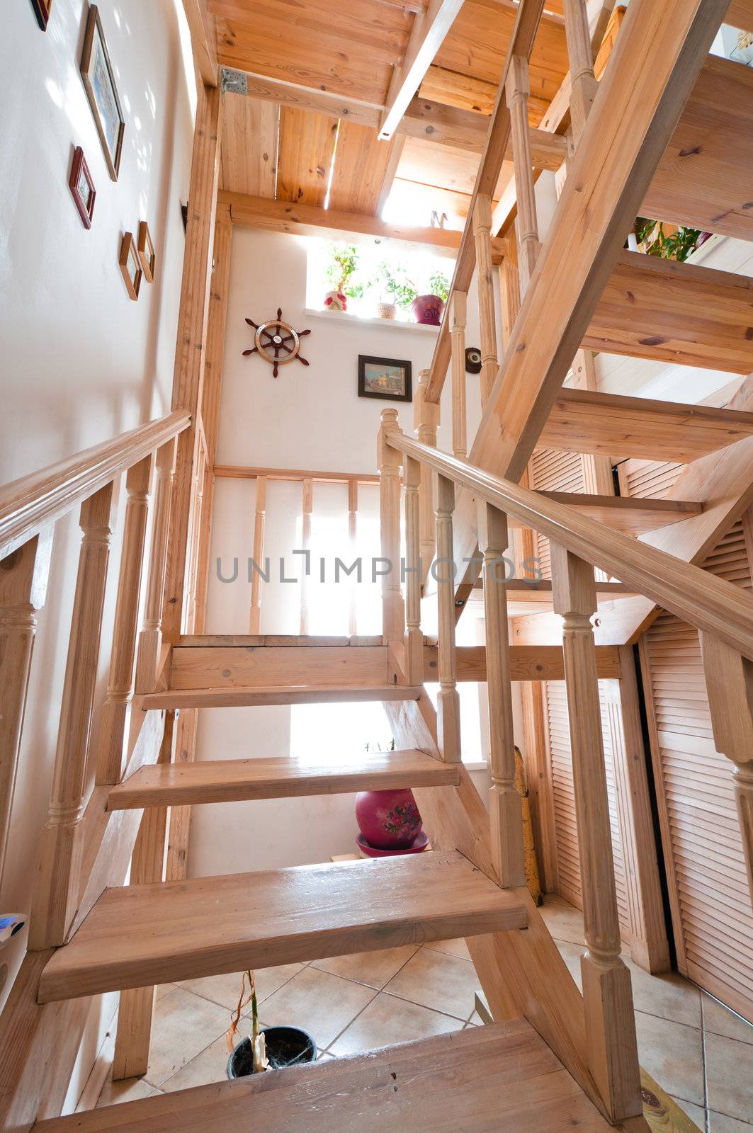 Wooden stairs inside house, colored beige with paintings on walls