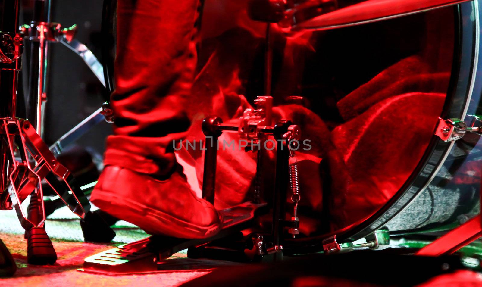 drummer plays in live concert under red lights