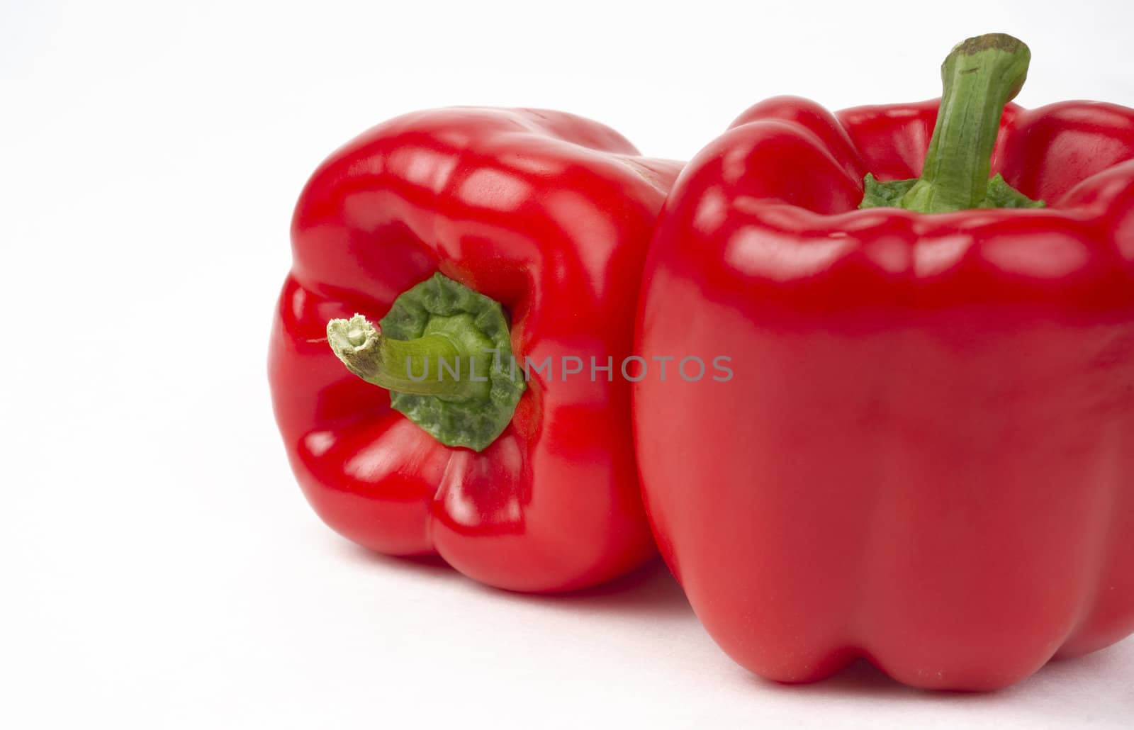 Pair of Bright Fresh Red Peppers Food Sits on White by ChrisBoswell