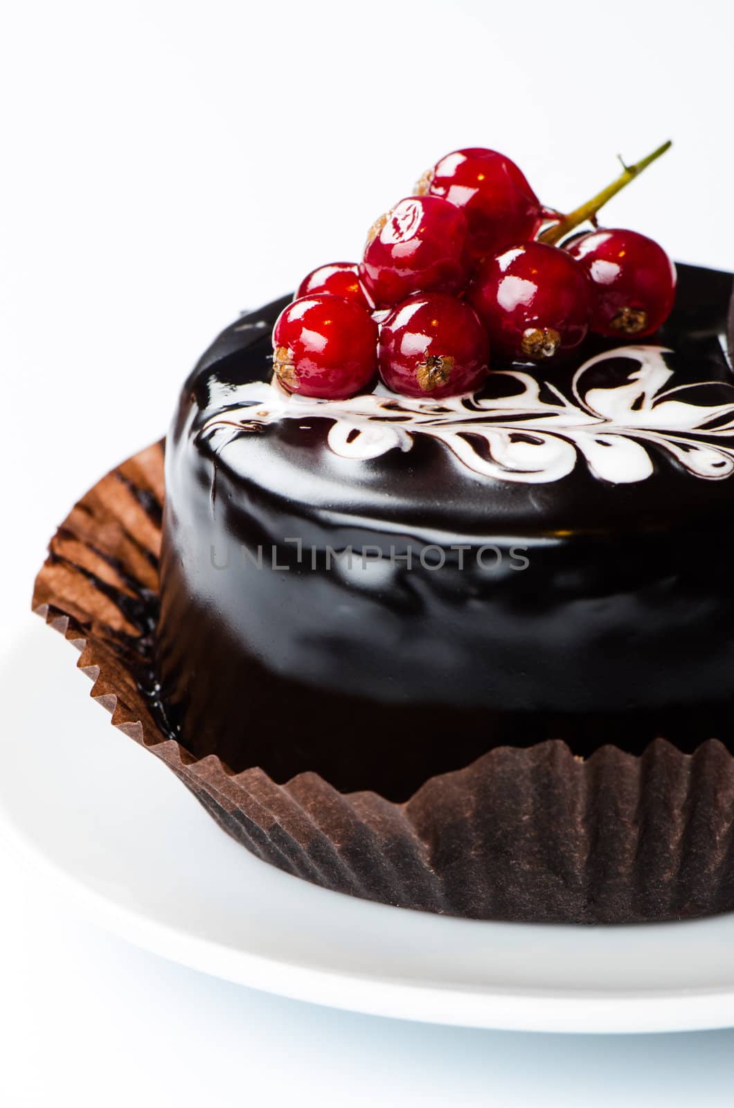 Сhocolate cake with redcurrants on white