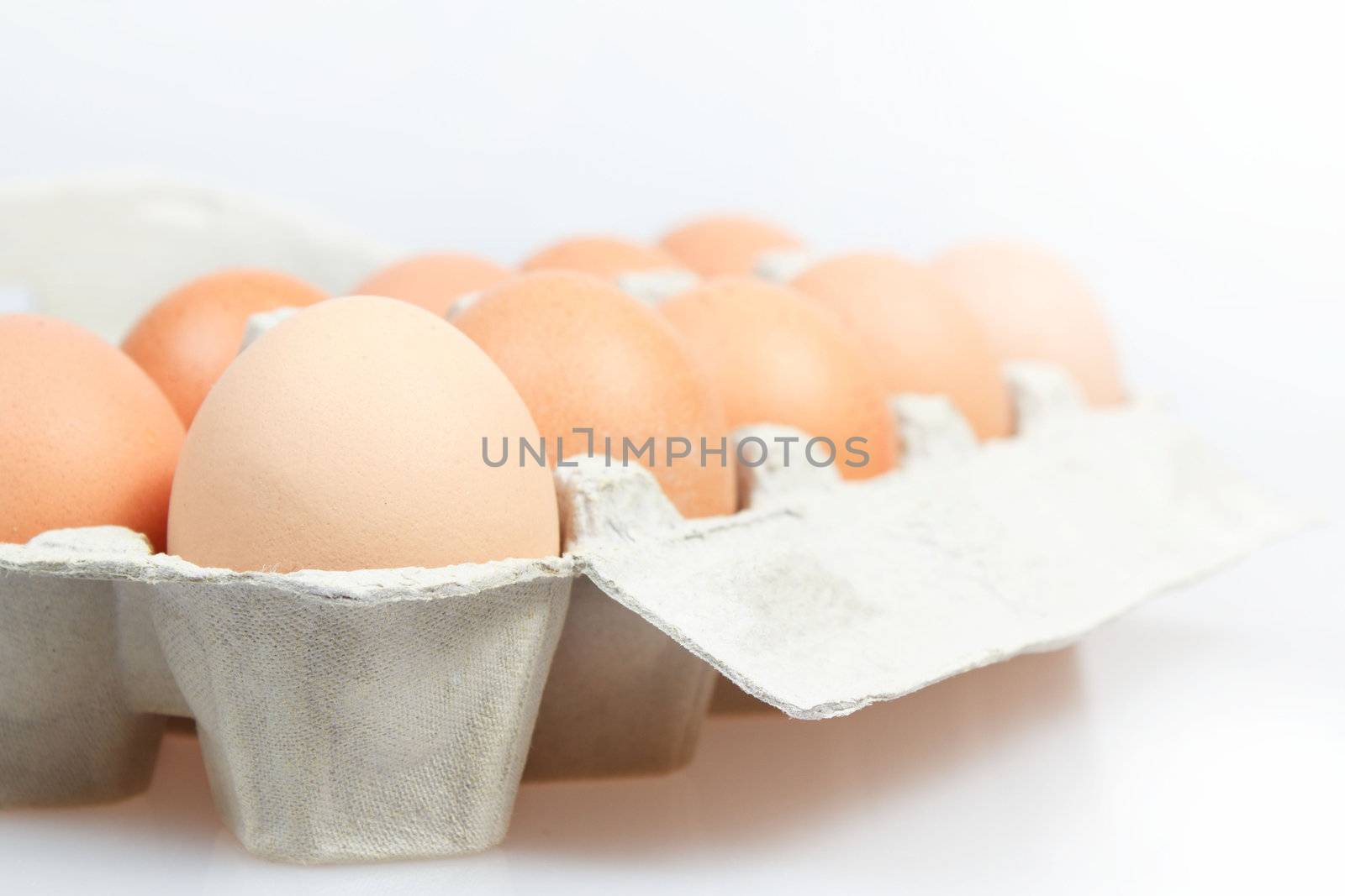 Fresh eggs in carton box on white background