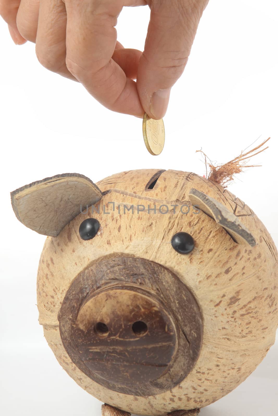 Saving, male hand putting a coin into piggy bank. 