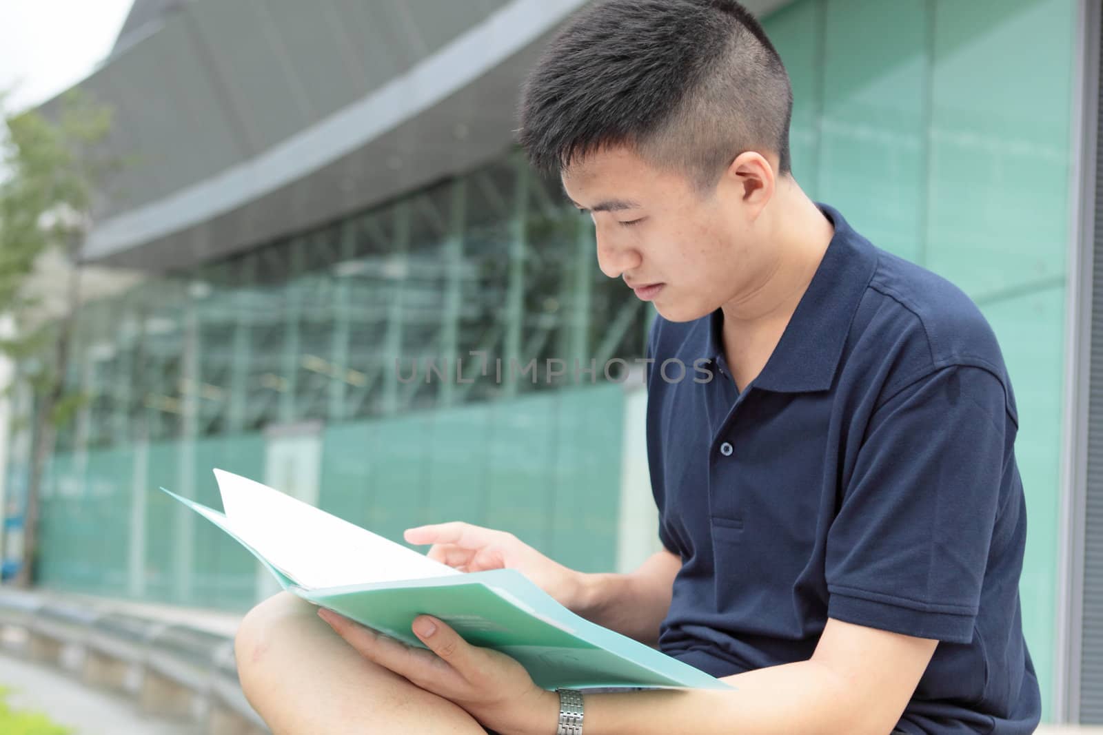 casual asian businessman texting on his book. 