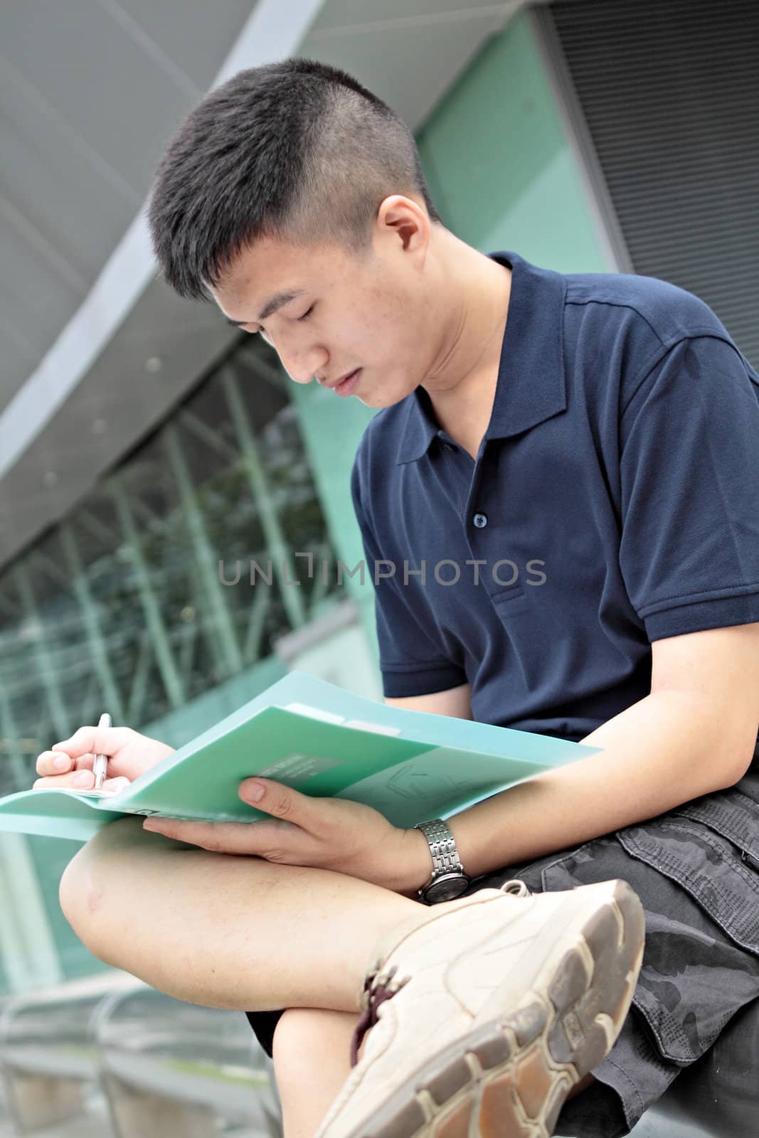 casual asian businessman texting on his book. 