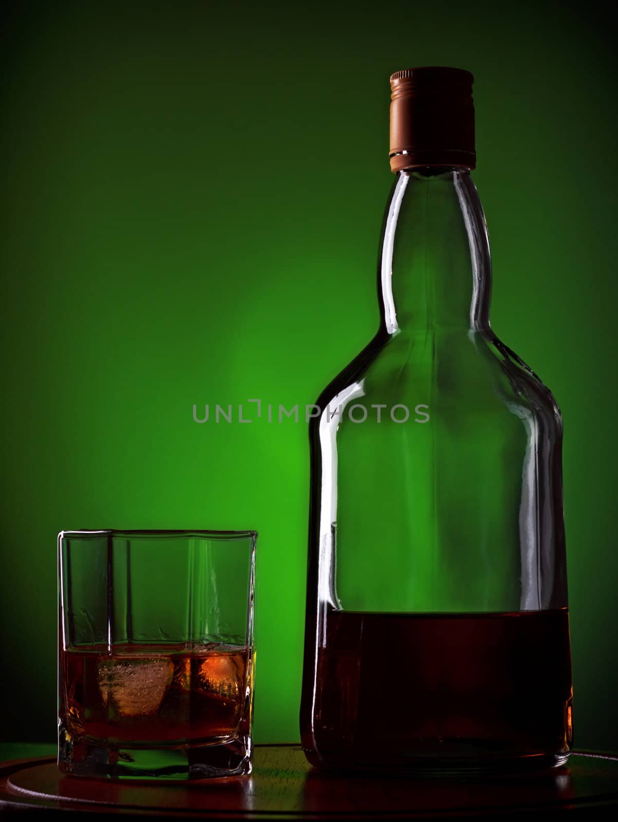 whiskey and glass on wooden tray, green background