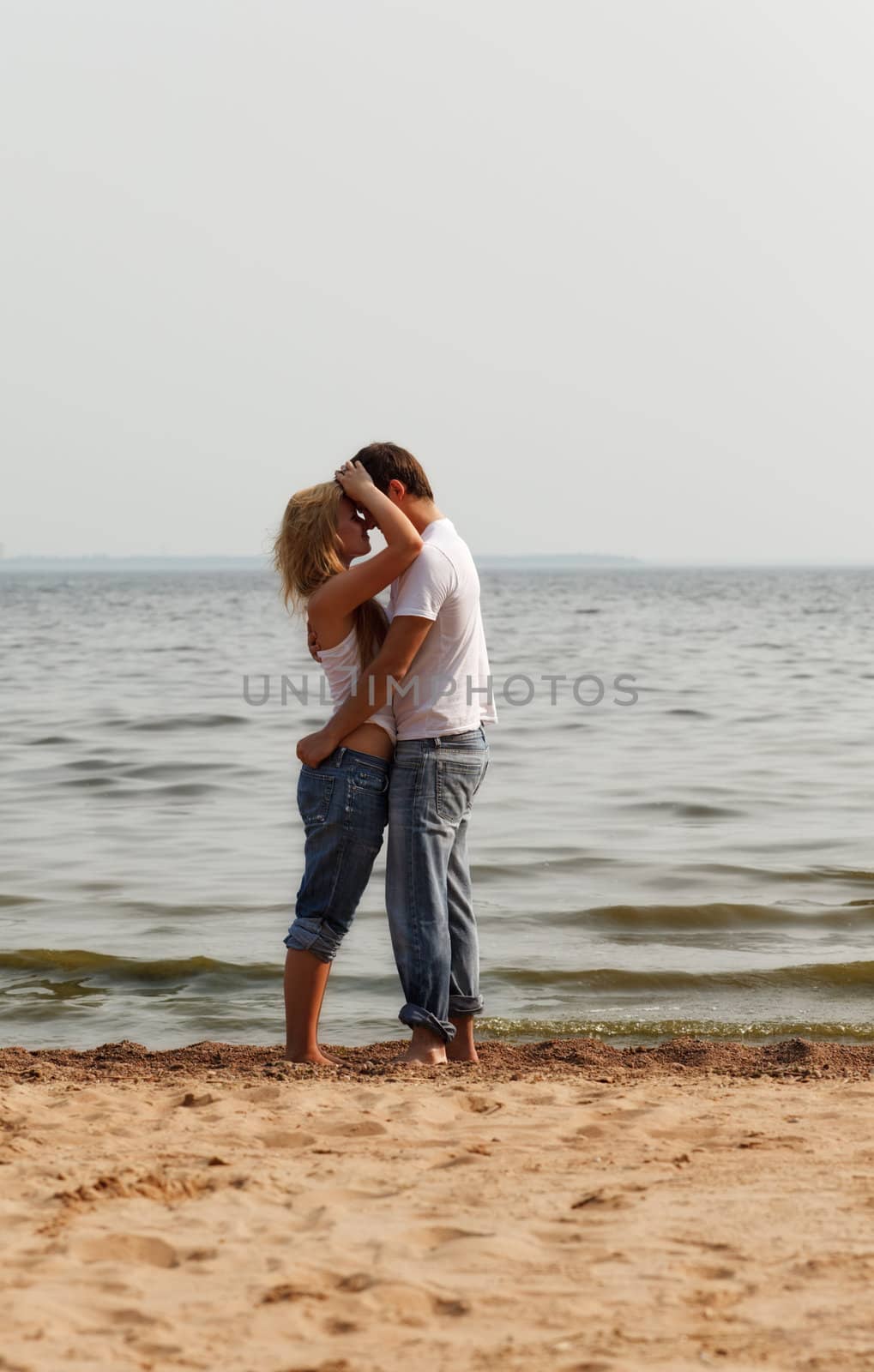 couple embrace on a beach by petr_malyshev