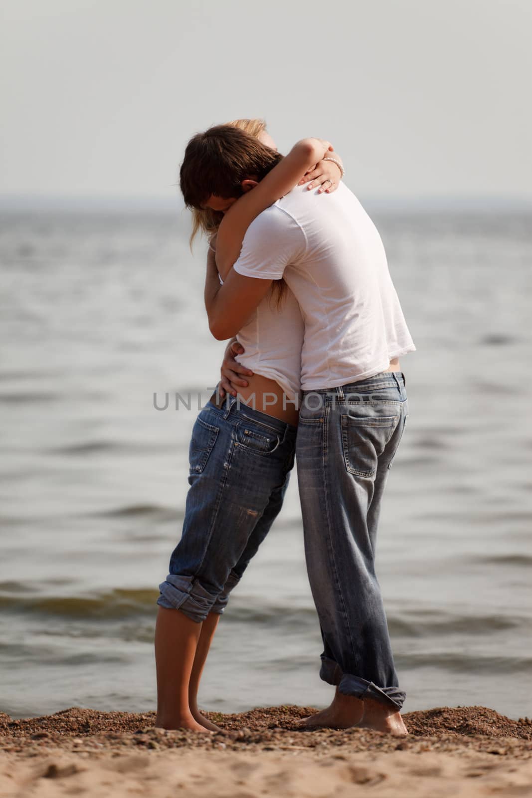 couple embrace on a beach by petr_malyshev