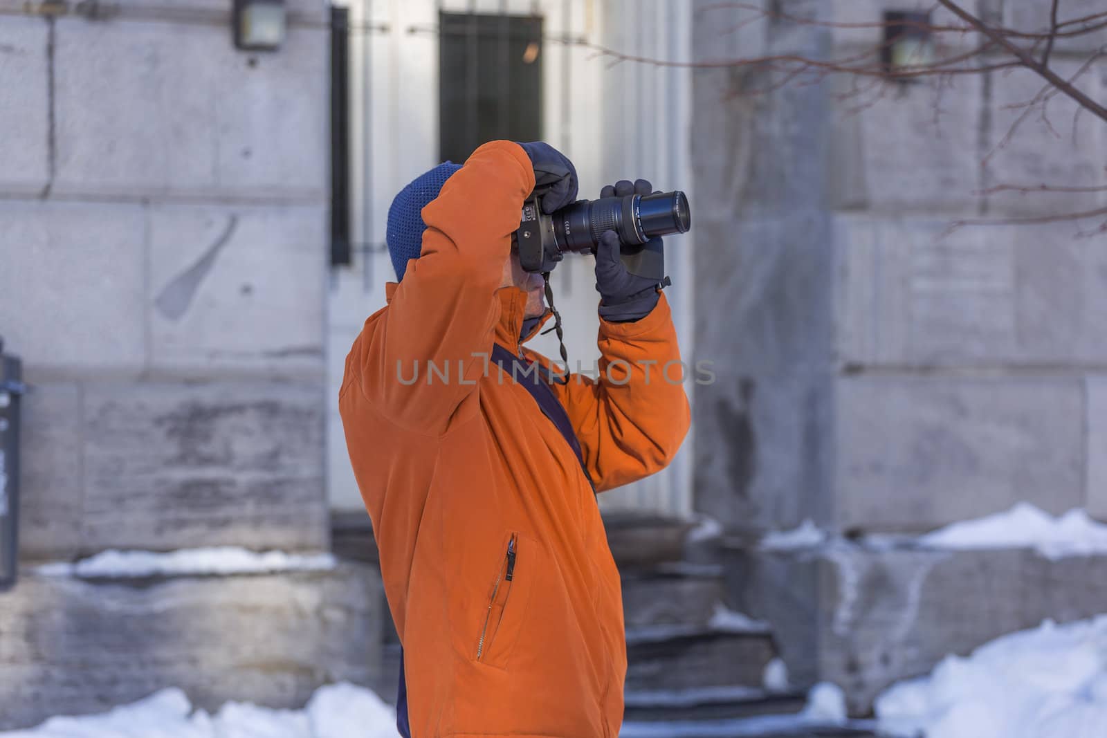 An experienced photographer in taking a picture of something in a cold winter day in Old Montreal, Quebec, Canada