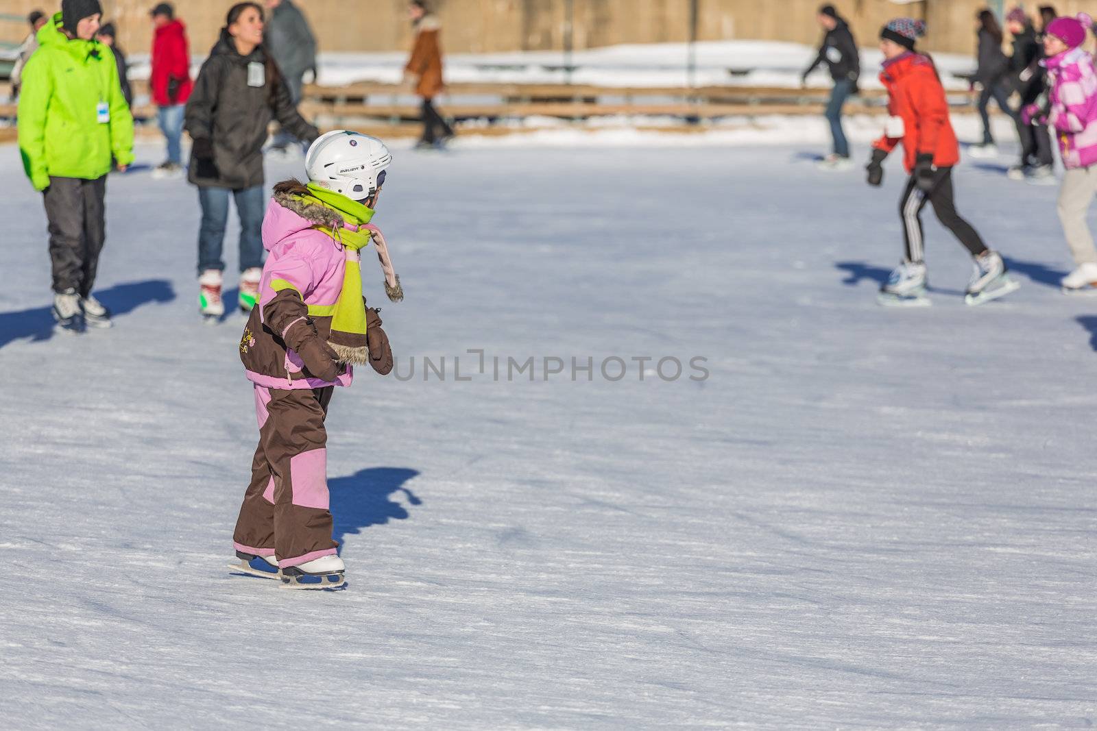 A young child is ice skating by petkolophoto