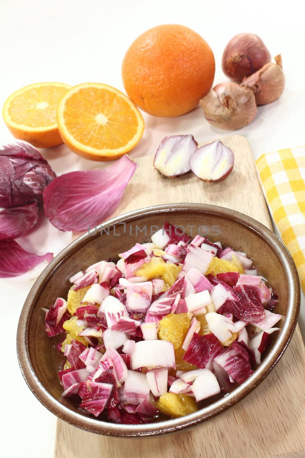 Chicory salad with a bowl of shallots and orange