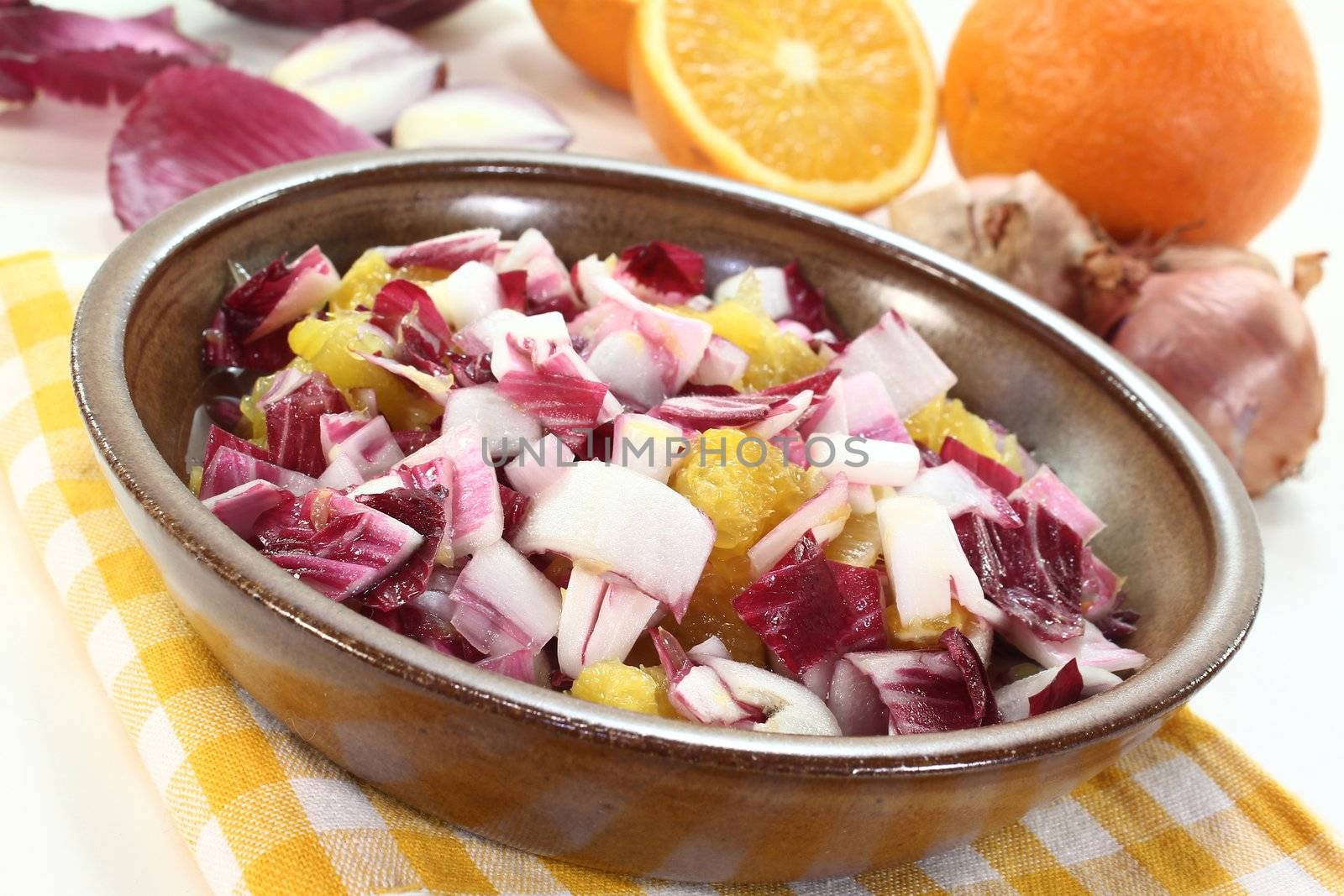 Chicory salad with a bowl of shallots and orange