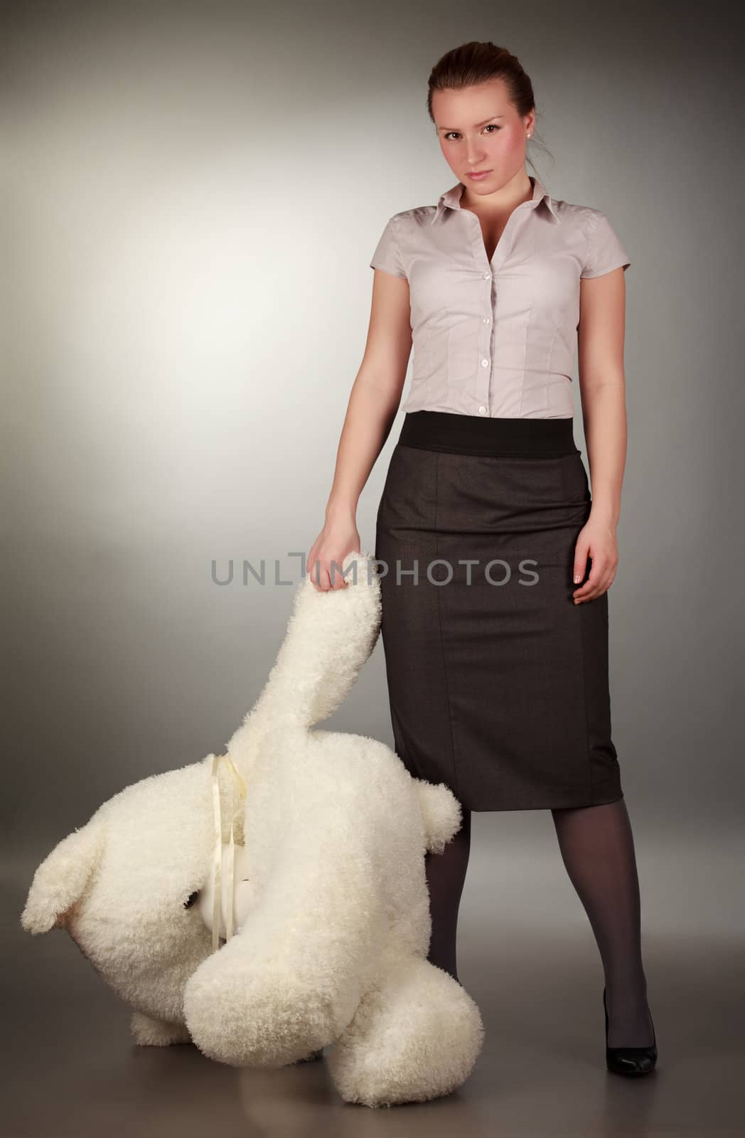 beautiful girl with toy bear, gray background