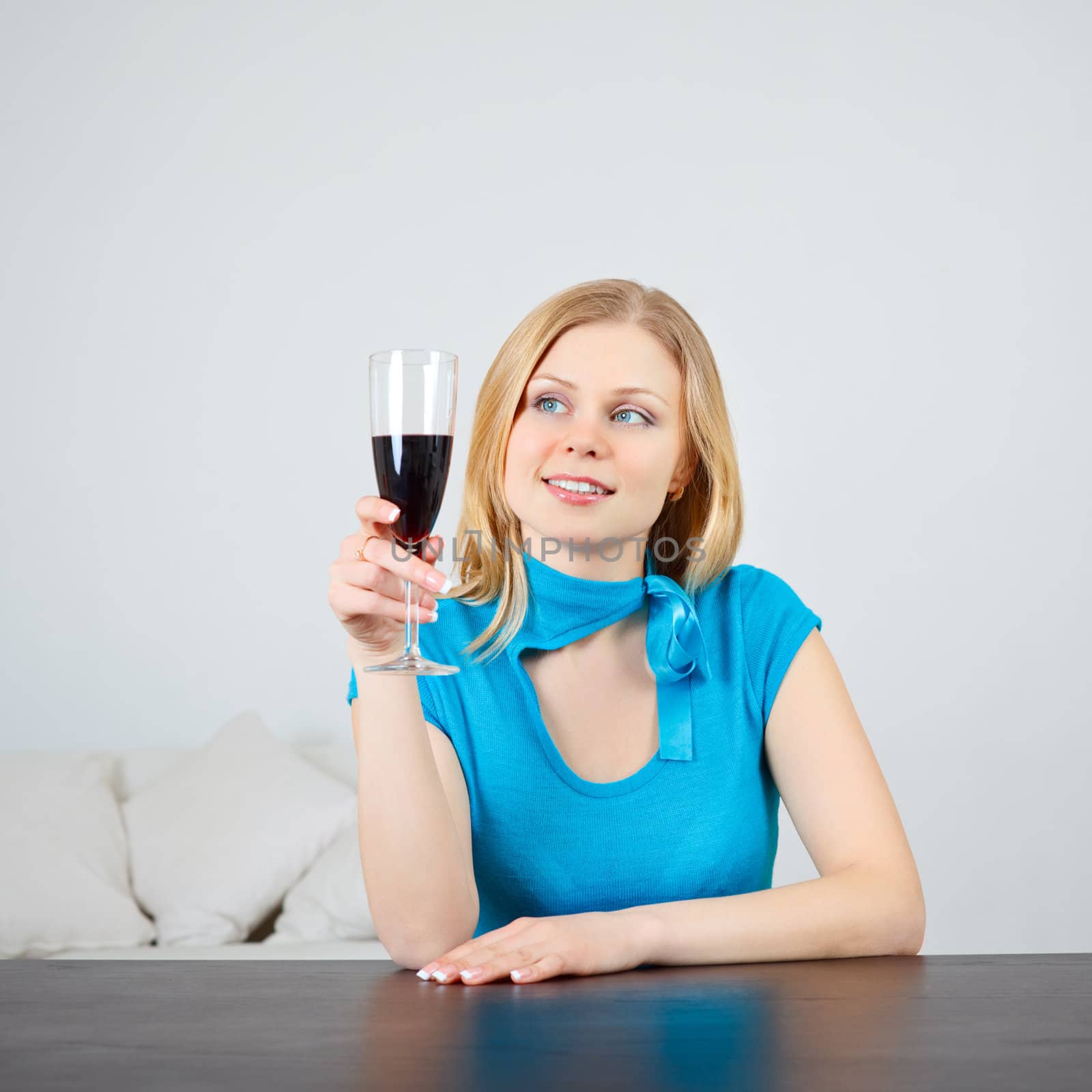 beautiful woman sitting at table drinking wine