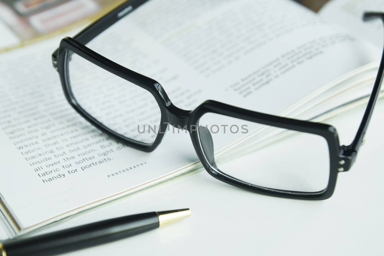 Glasses and a pen on a book