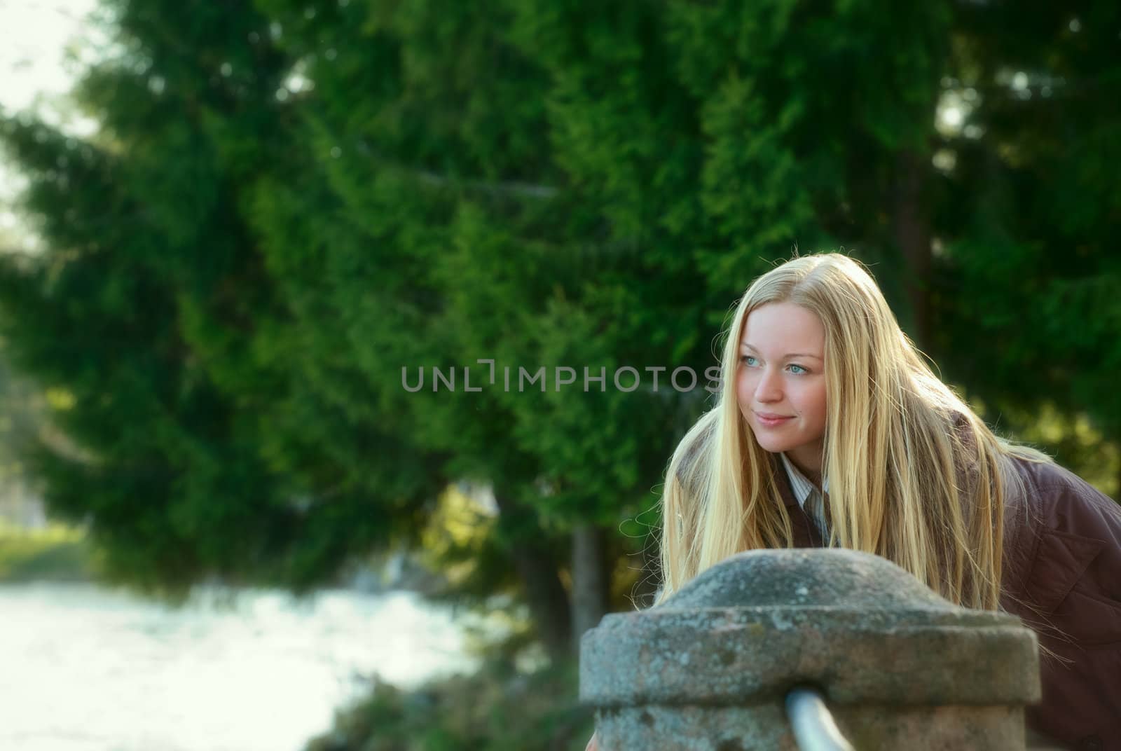 beautiful blond woman standing on river bank