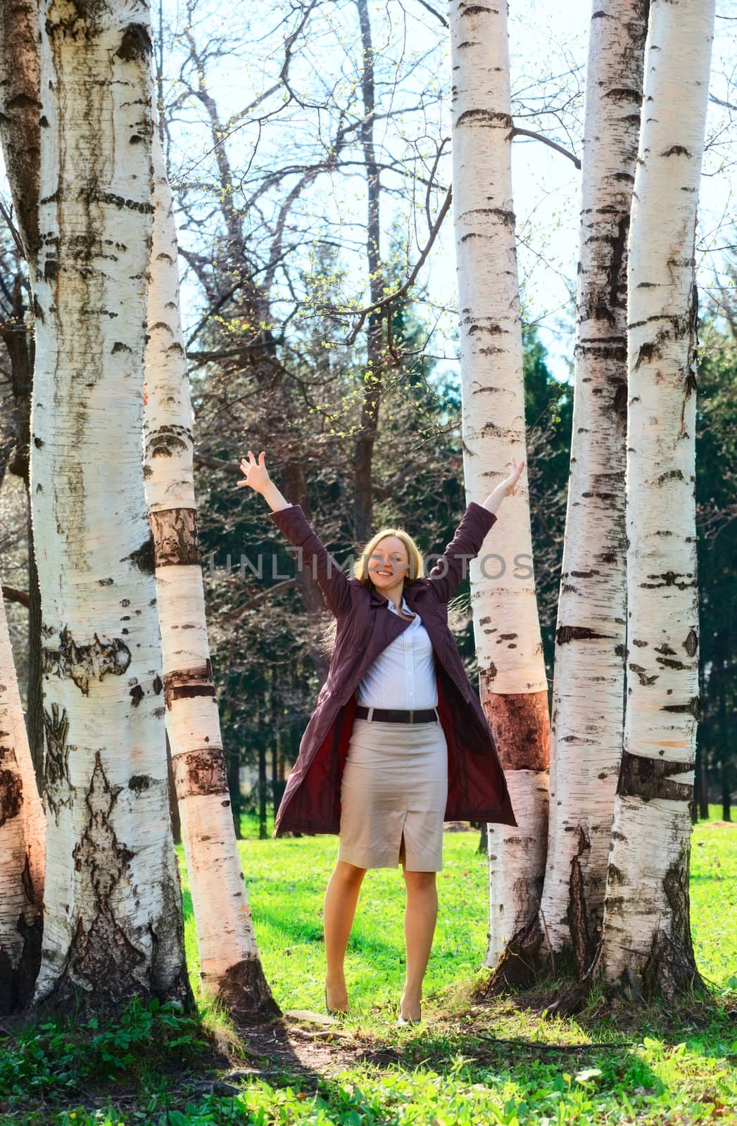beautiful smiling blond woman in birch park