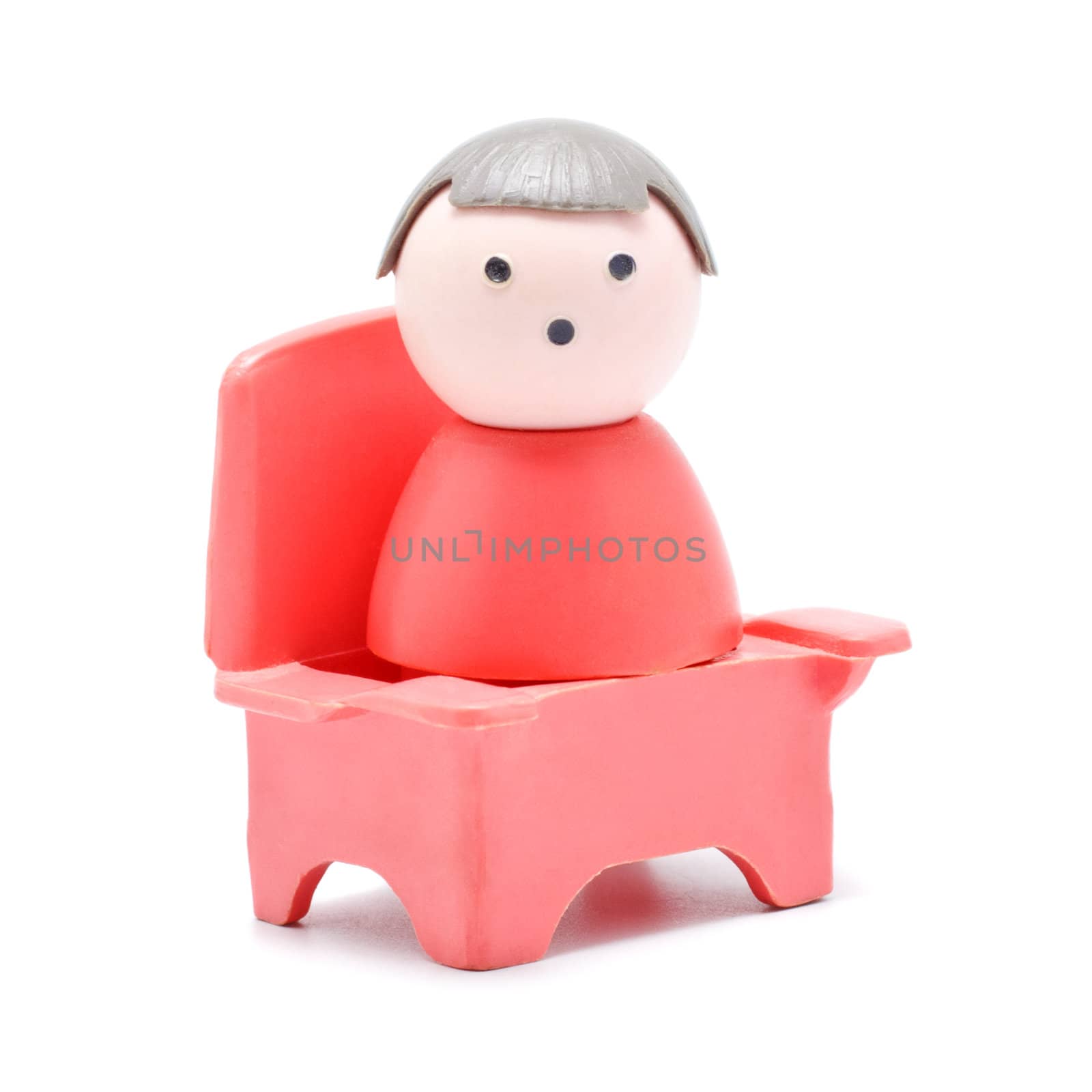 toy baby sitting on chair, isolated on white