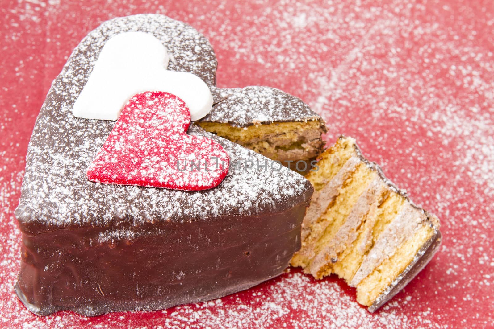 Heart shaped slice of a chocolate-cake on red  plate