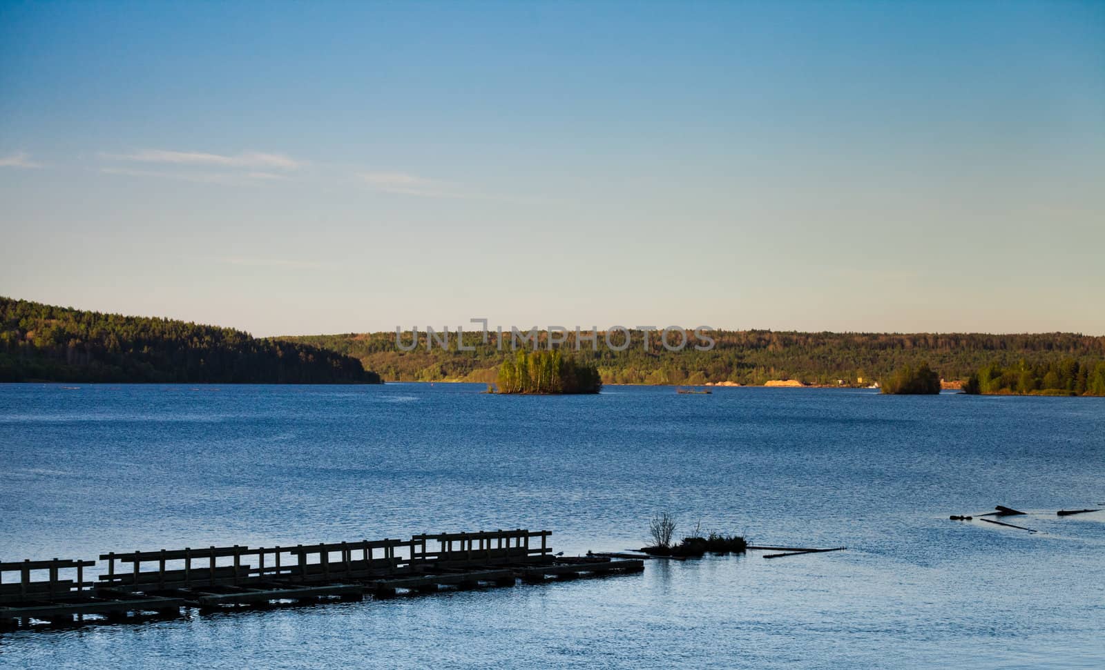 wide river with old wooden dam at sunset