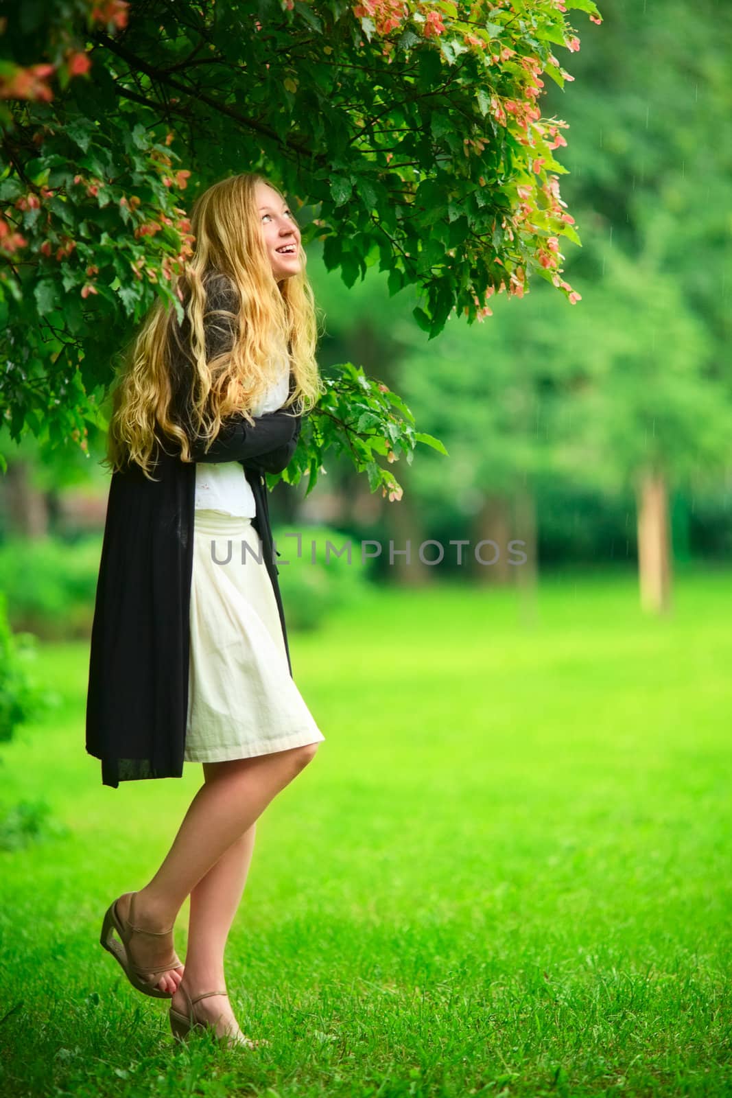 girl hiding from the rain under branch of tree