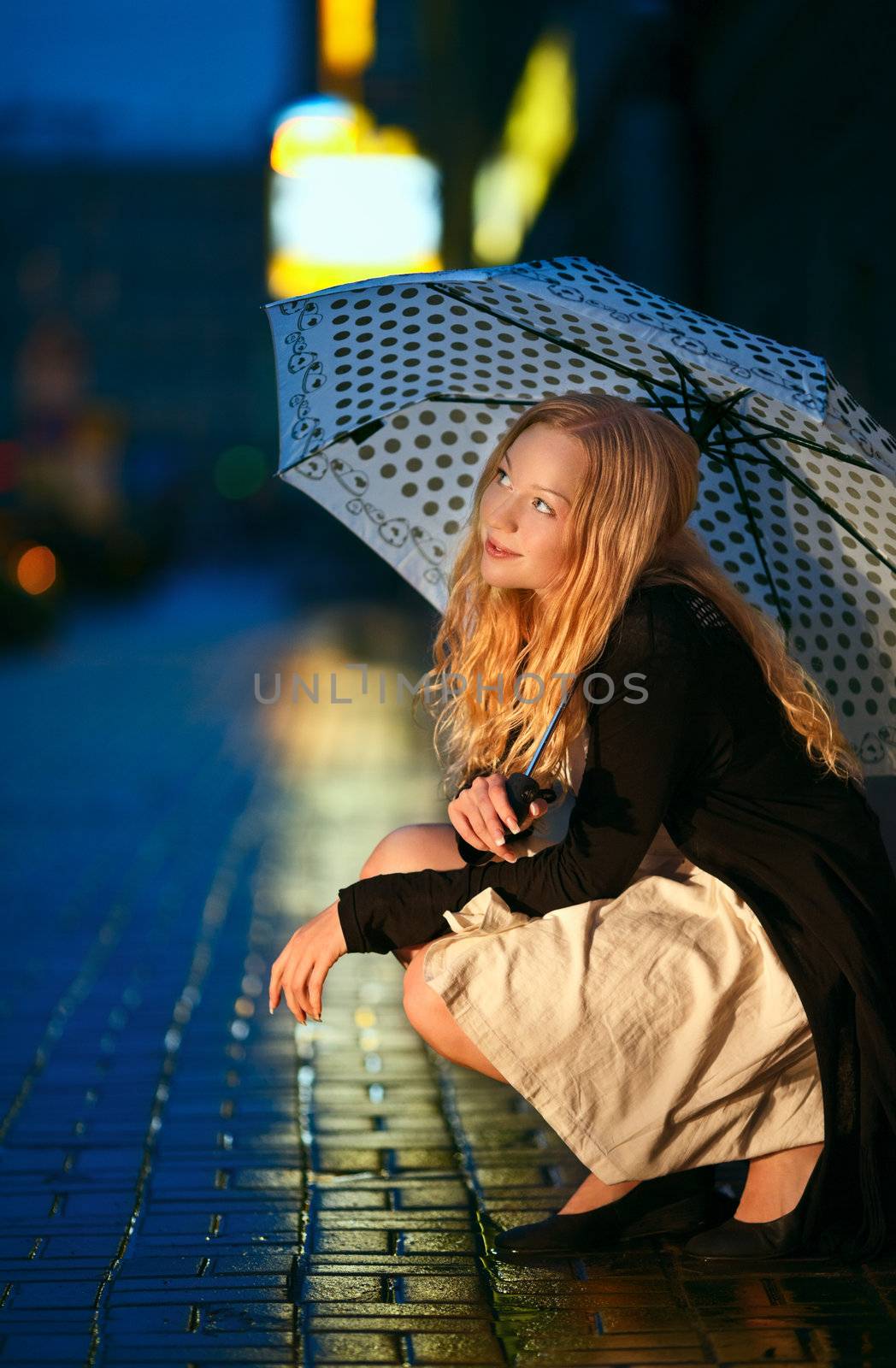 girl with umbrella on street at night