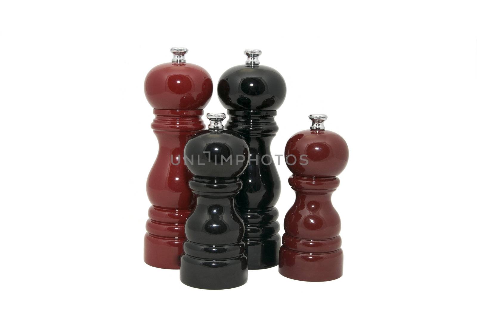 Four wooden pepper Mills on a white background