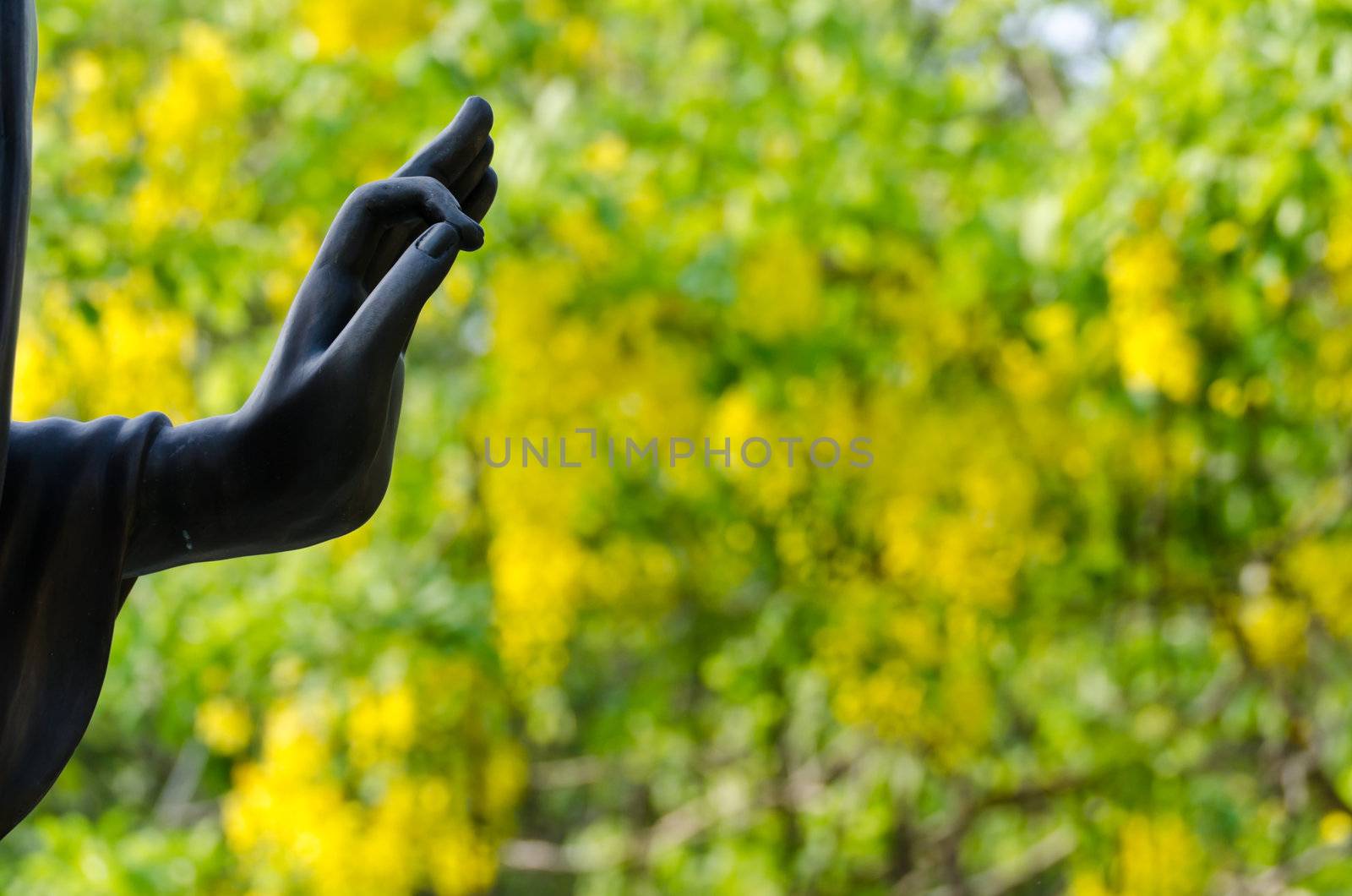 Hand of Buddha statue in Thailand's temple and yellow background