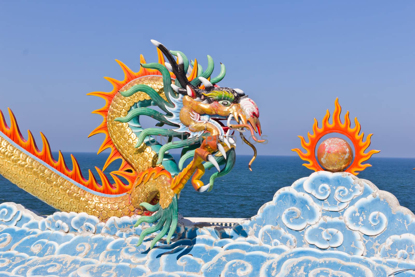 dragon statue against blue sky in chinese temple by tungphoto