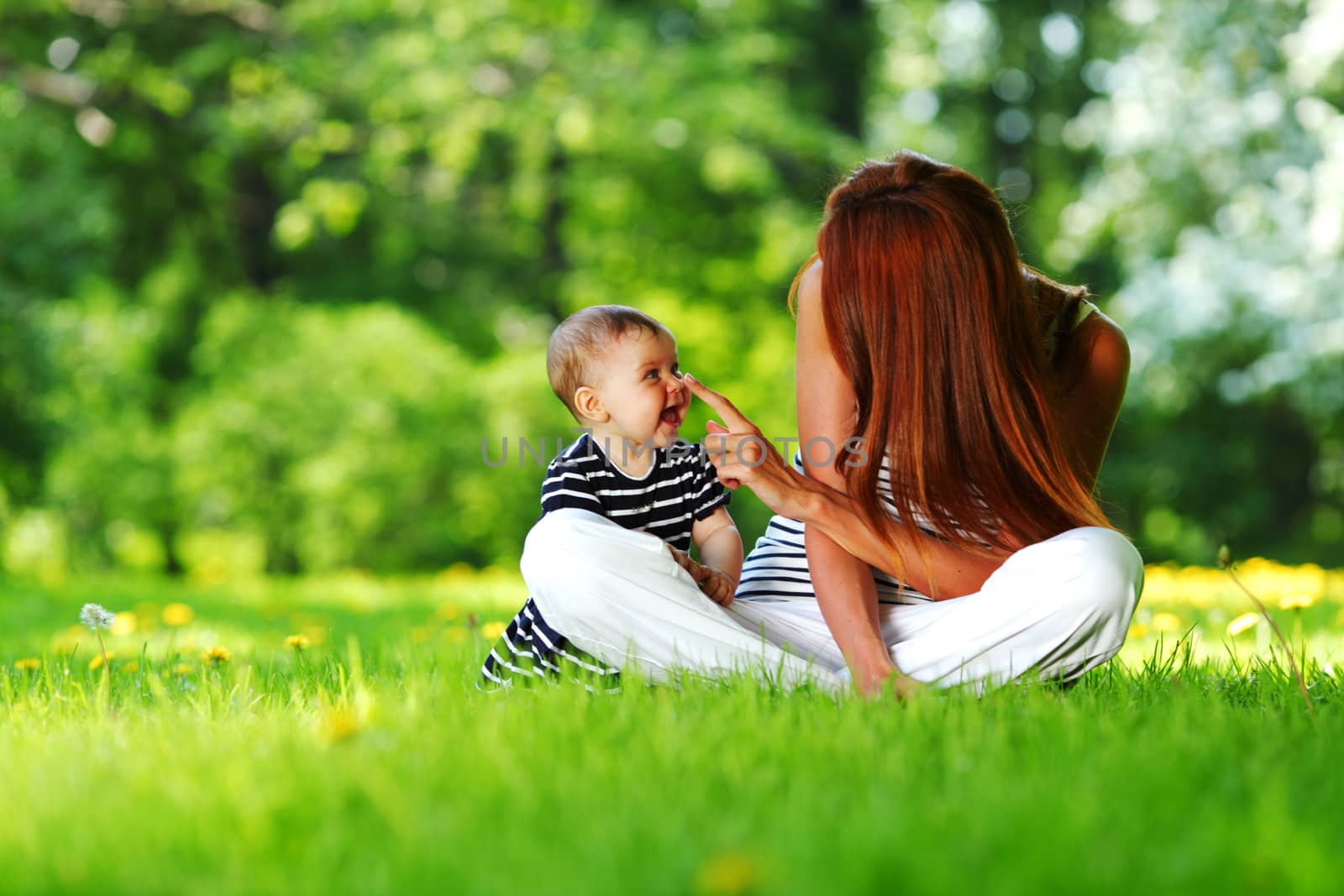Happy mother and daughter on the green grass