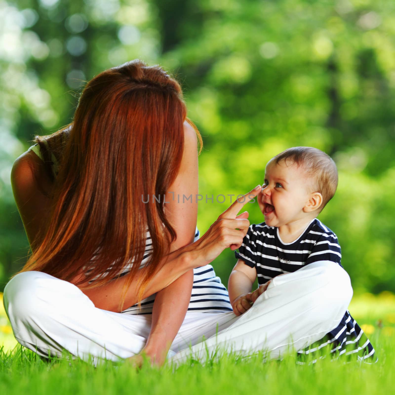 Happy mother and daughter on the green grass