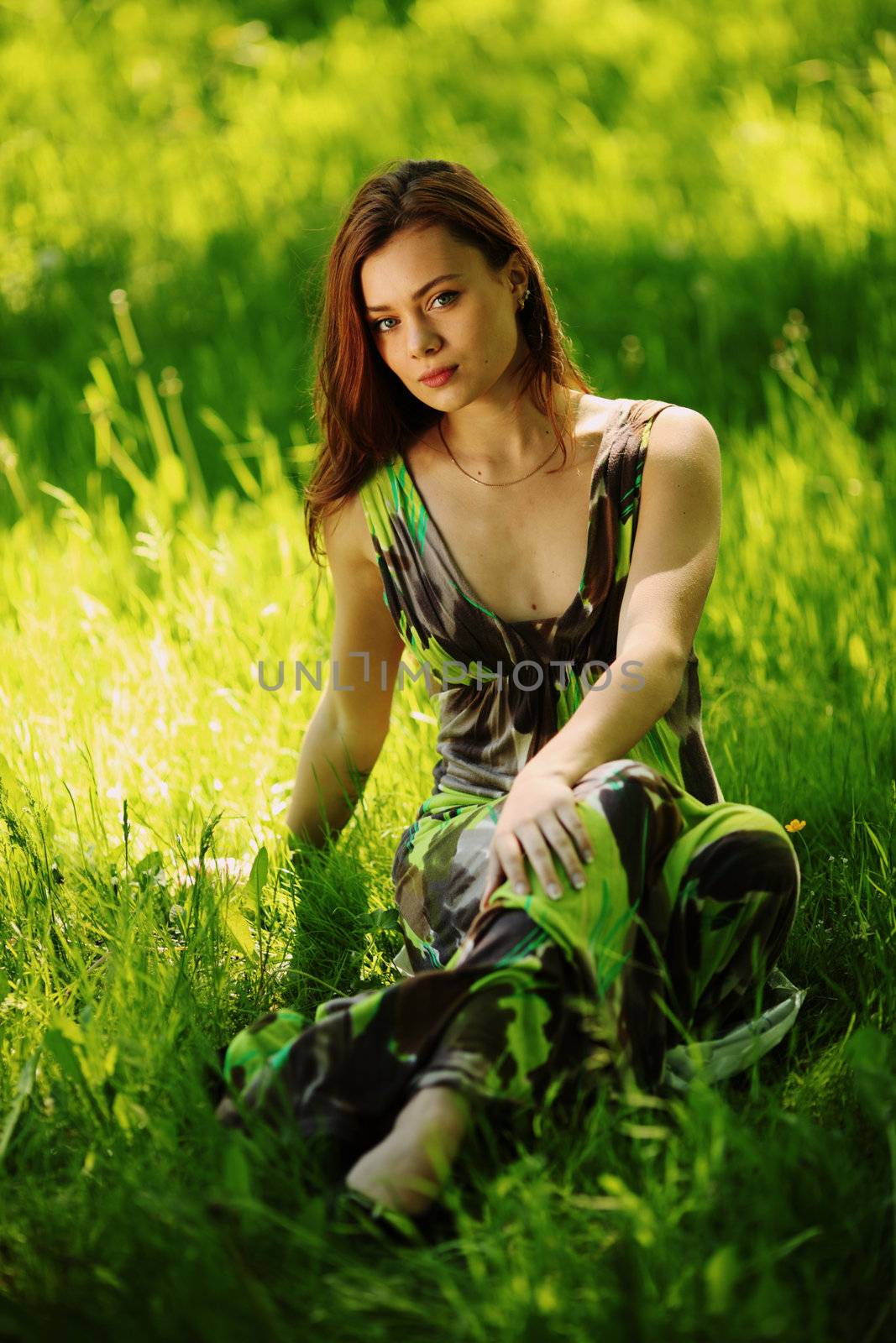 brunette sitting on green grass by Yellowj